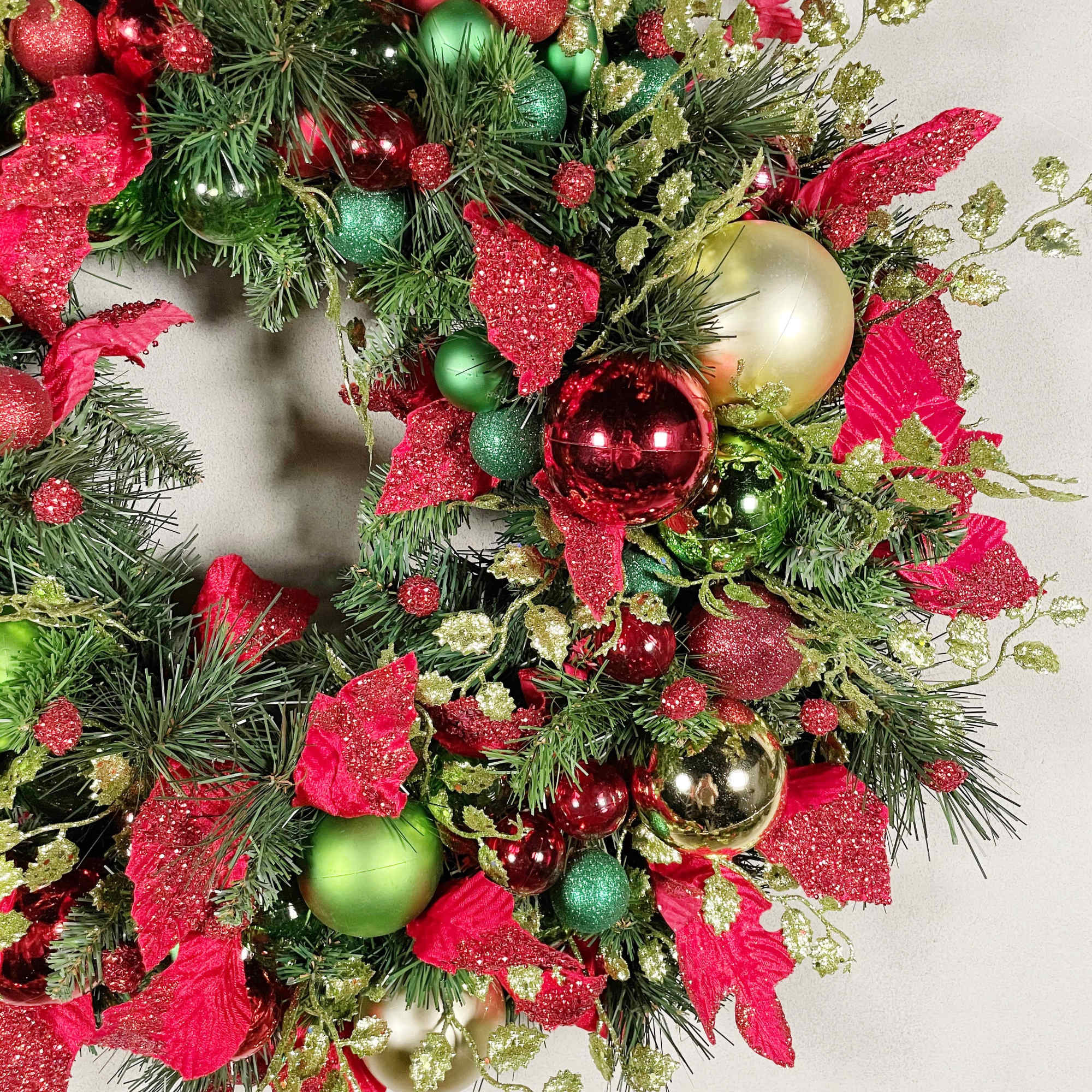 A traditional holiday wreath with beautiful red and green ornaments and a