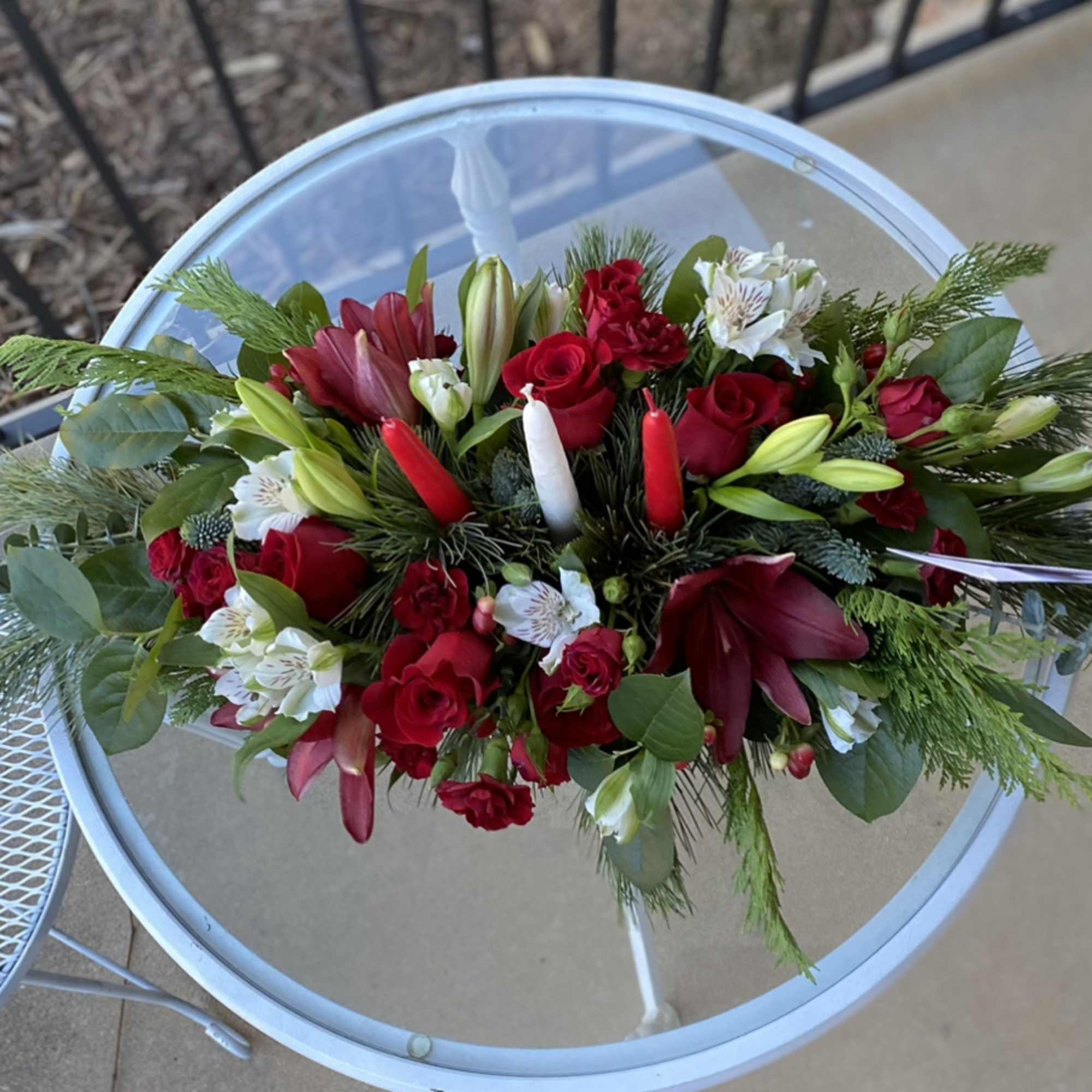 Red, and white flowers in lush Christmas greens make up this lovely