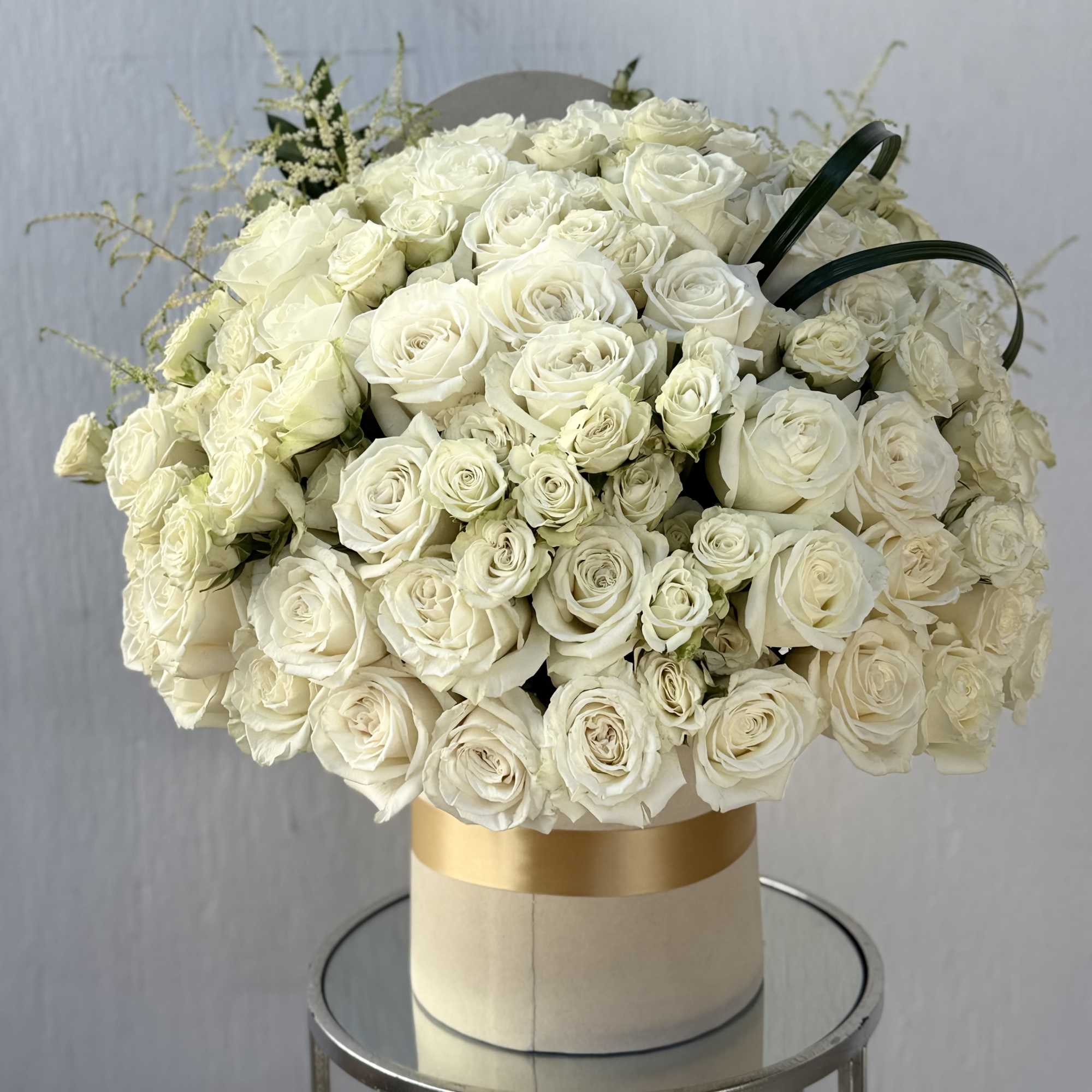 A luxurious arrangement featuring 50 premium white roses paired with delicate white