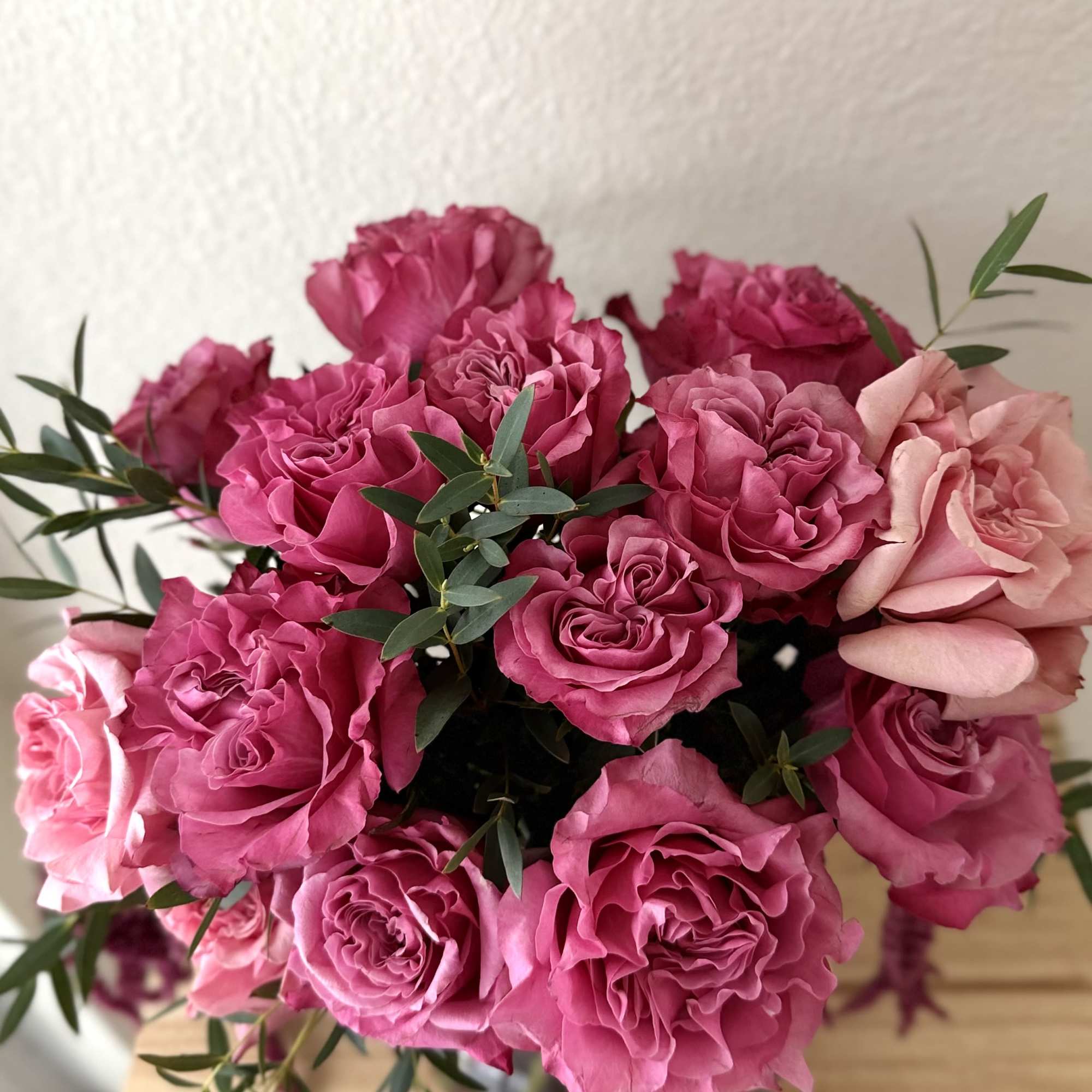 A lush, vibrant arrangement of rich pink roses paired with cascading amaranthus