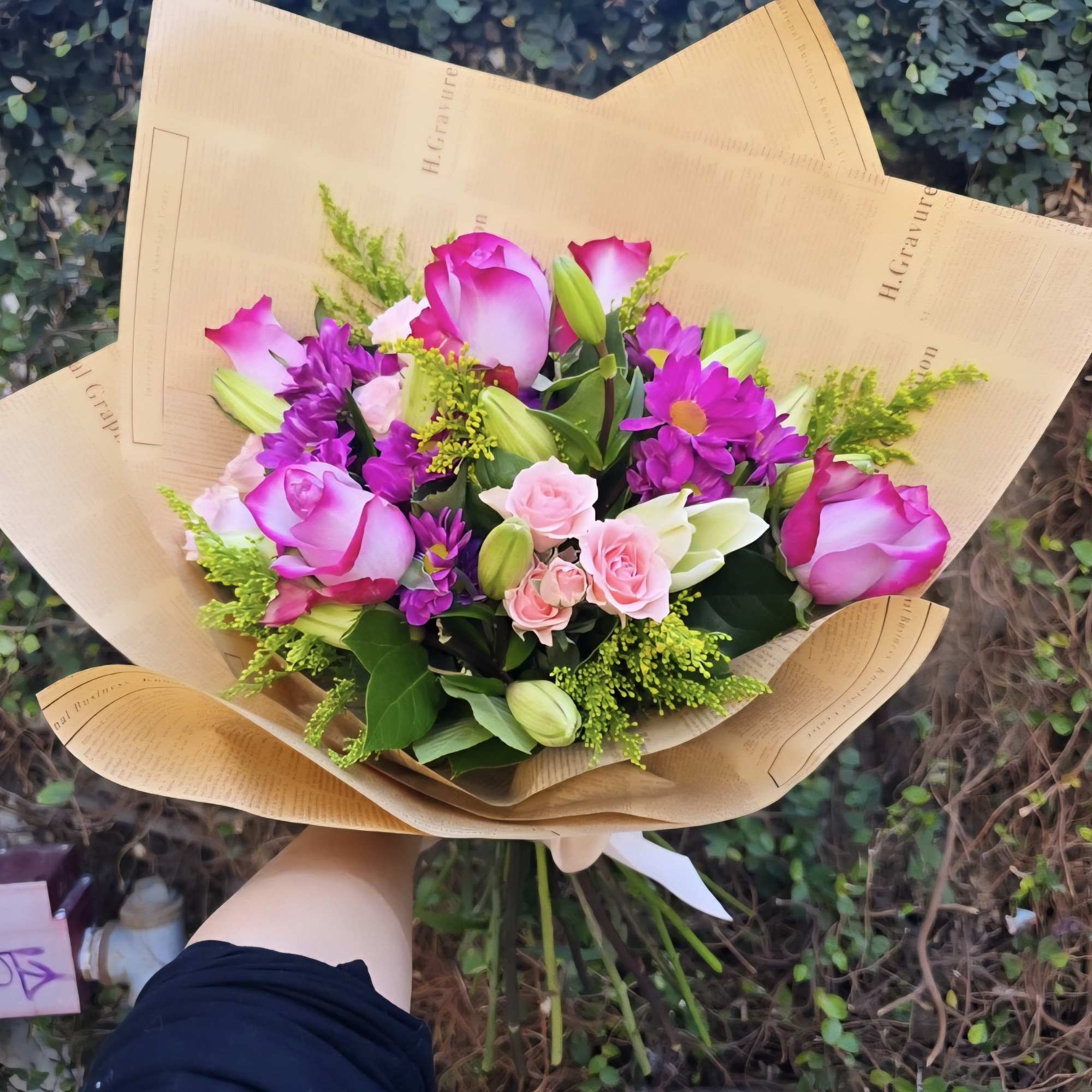 A bouquet of purple and pink in season florals wrapped in paper!