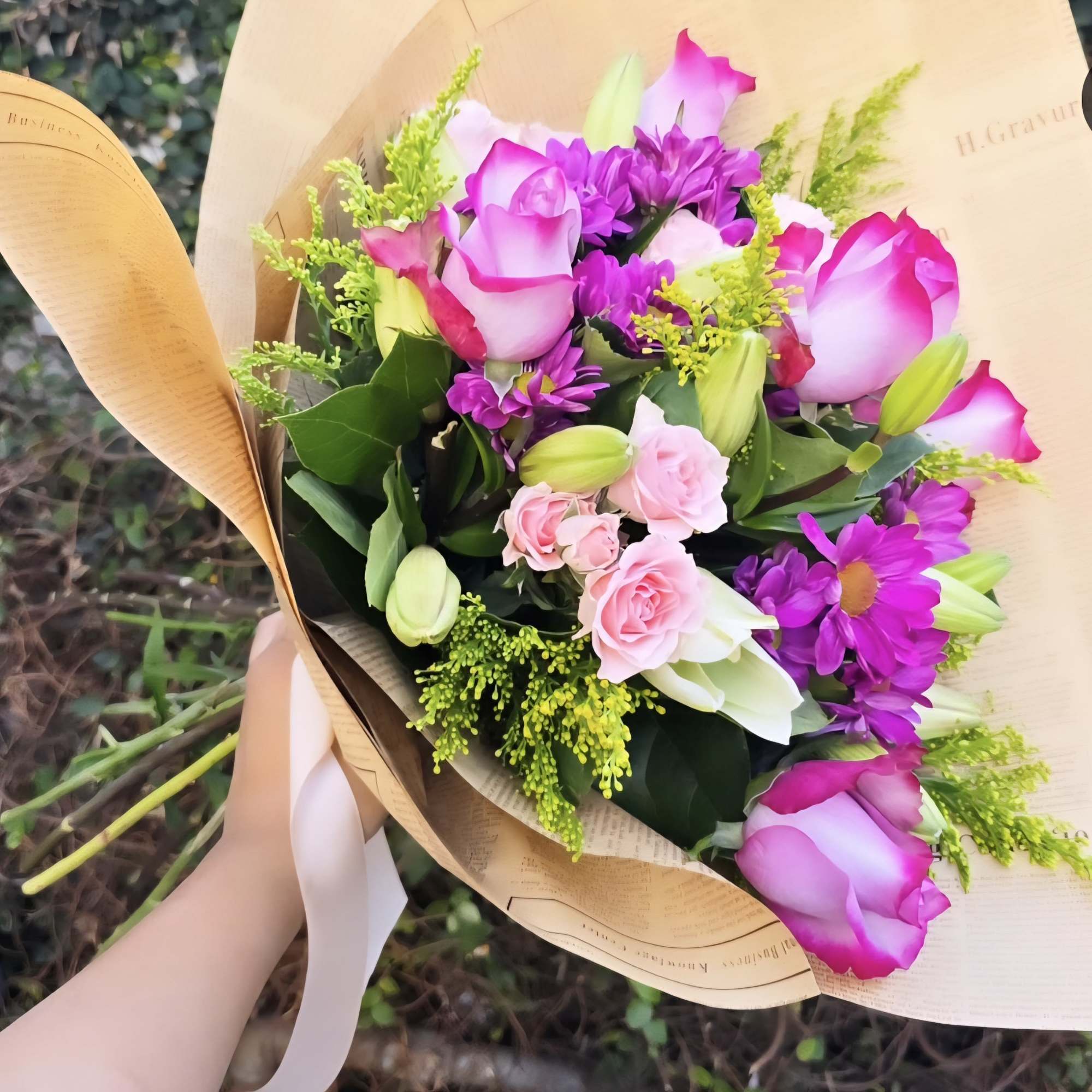 A bouquet of purple and pink in season florals wrapped in paper!