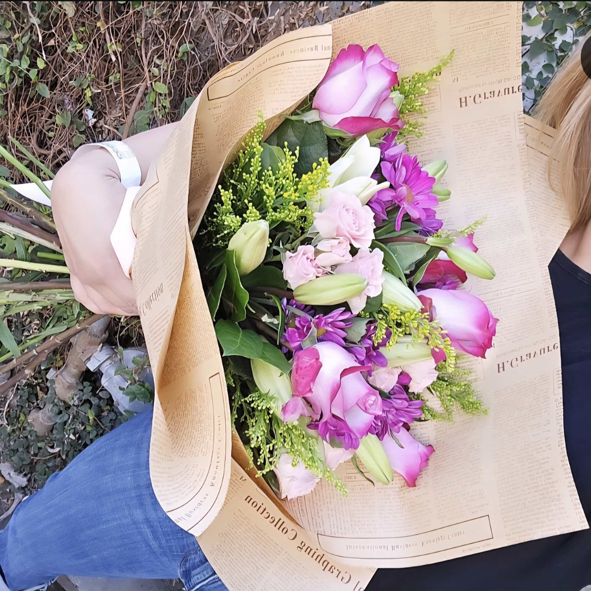 A bouquet of purple and pink in season florals wrapped in paper!