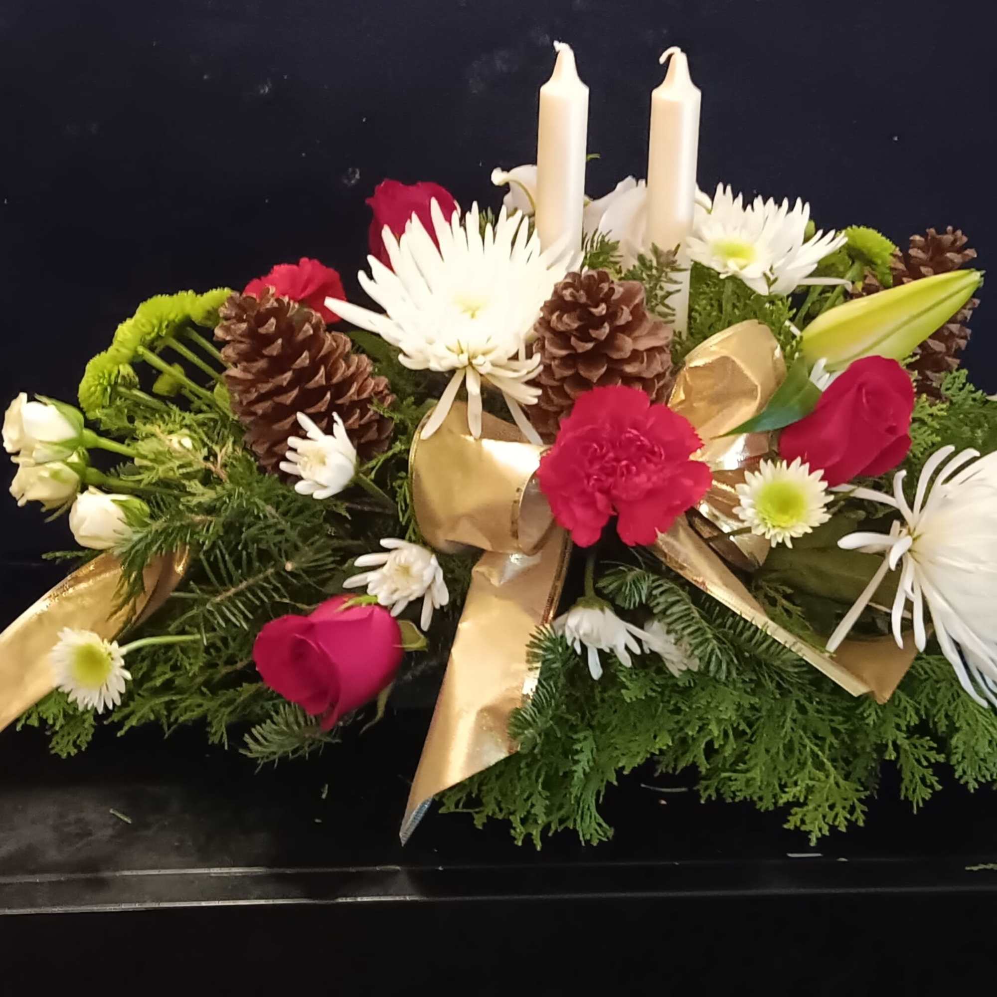 Mixed floral Arrangement with candle accented by fragrant greens and and pine