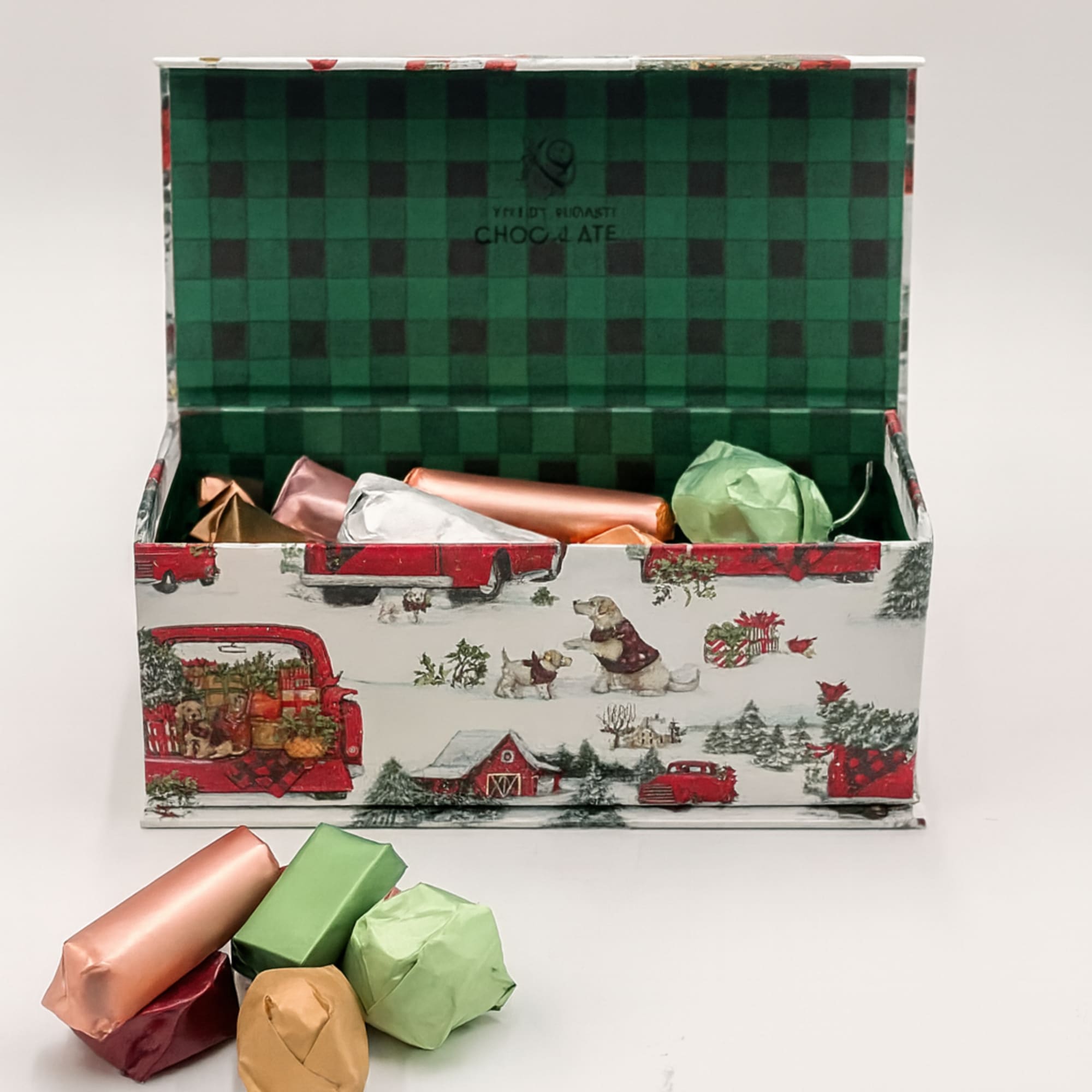 A festive holiday chocolate box wrapped in charming winter village artwork, filled