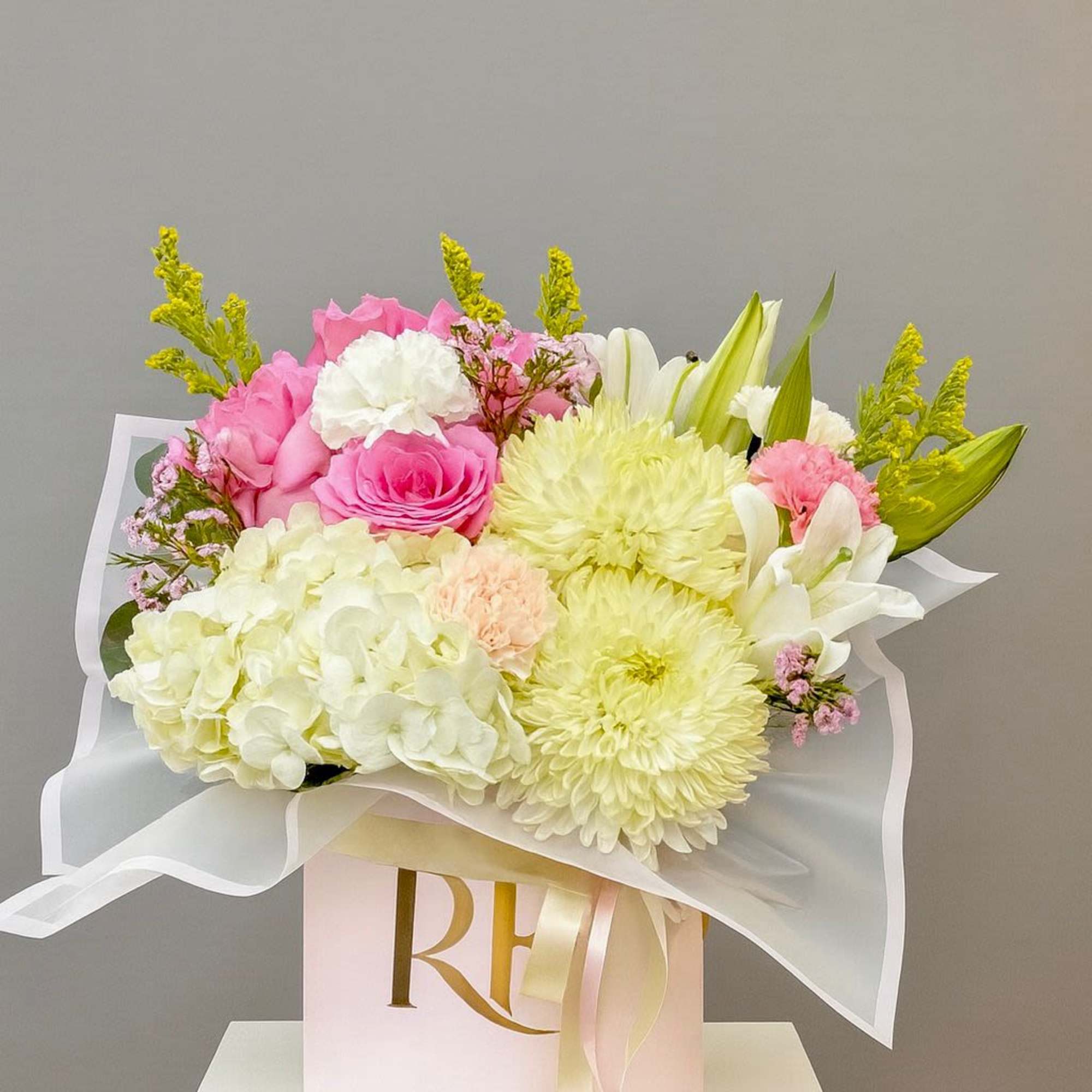 A curated mix of pink and white lilies, roses, carnations, and spider