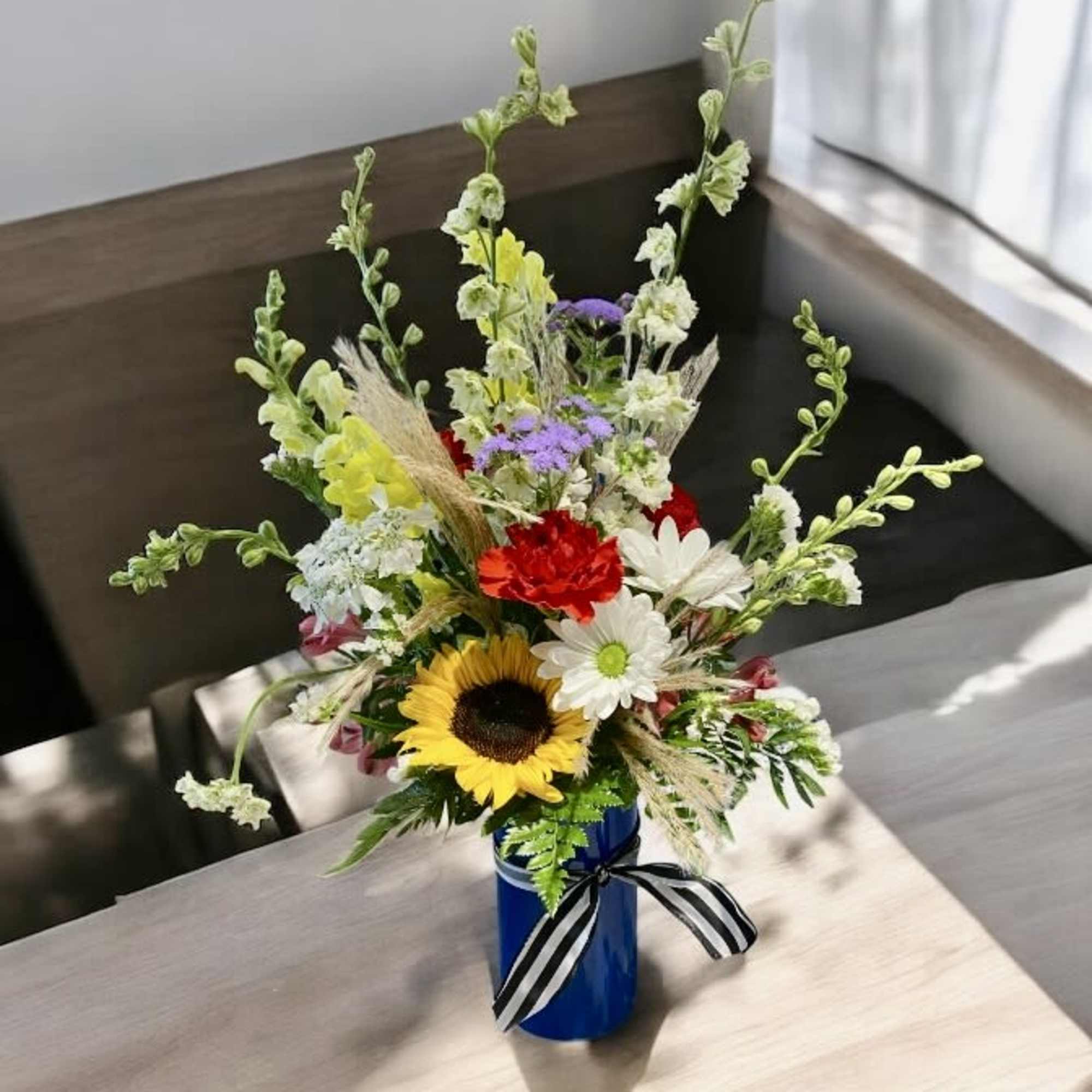  Meadow look flowers in a beautiful blue cylinder vase. Colors and