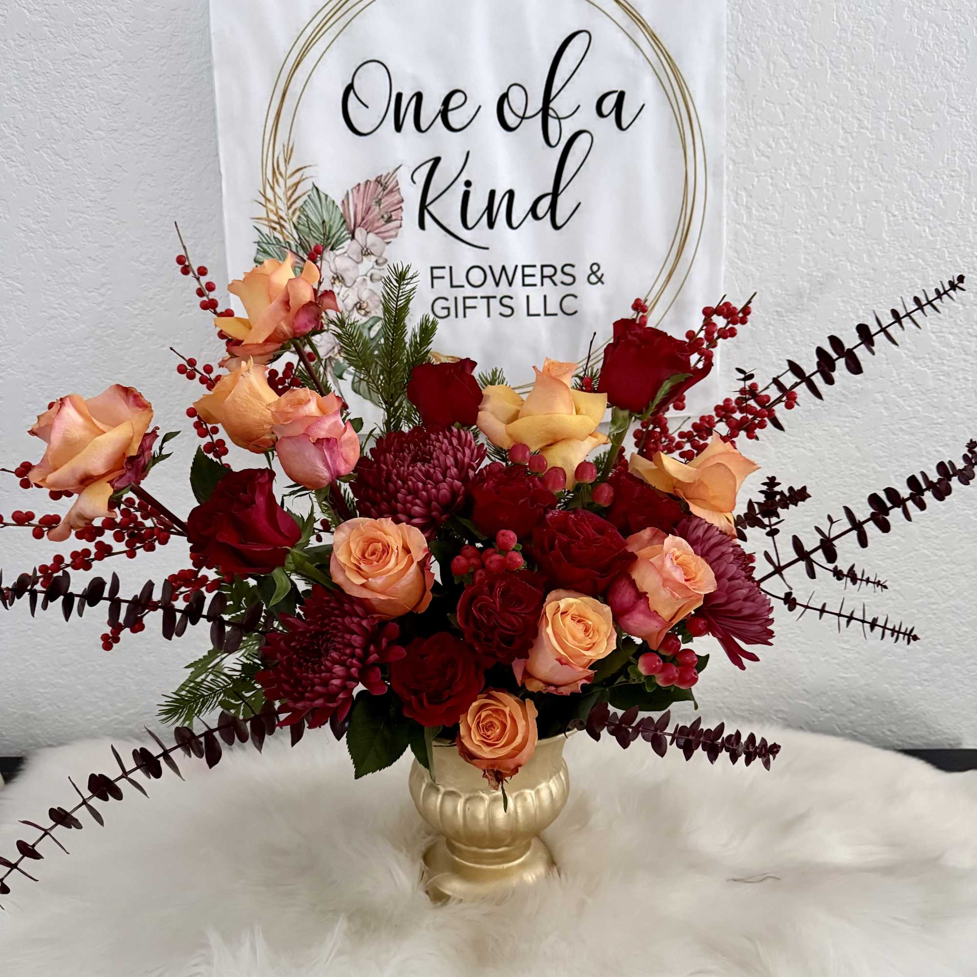 Aluxurious fall-inspired arrangement featuring vibrant orange and deep burgundy roses, rich chrysanthemum