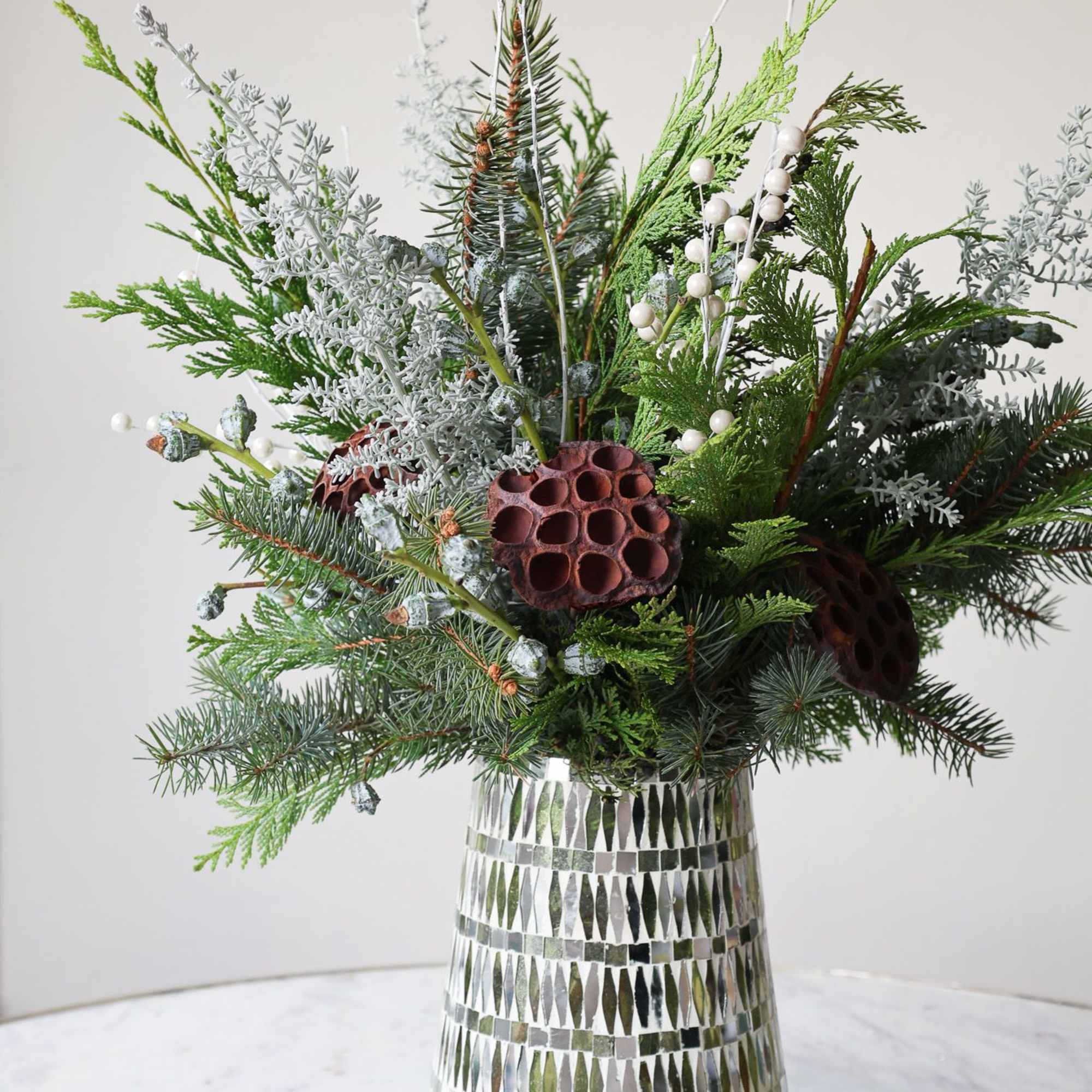 Winter greens and frosted foliage with some berry accents and lotus pods