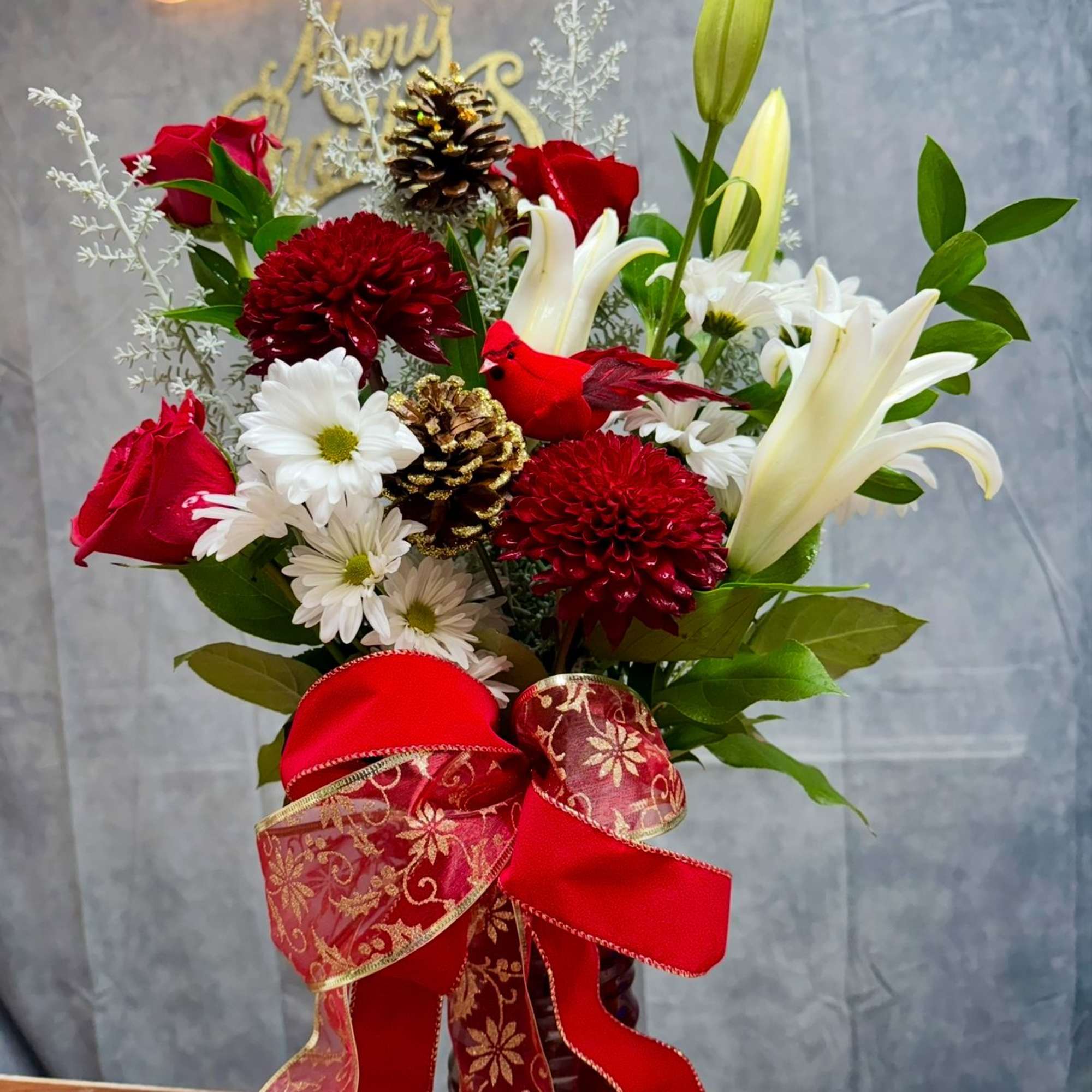 A joyful holiday vase featuring rich red blooms, snowy whites, fragrant lilies