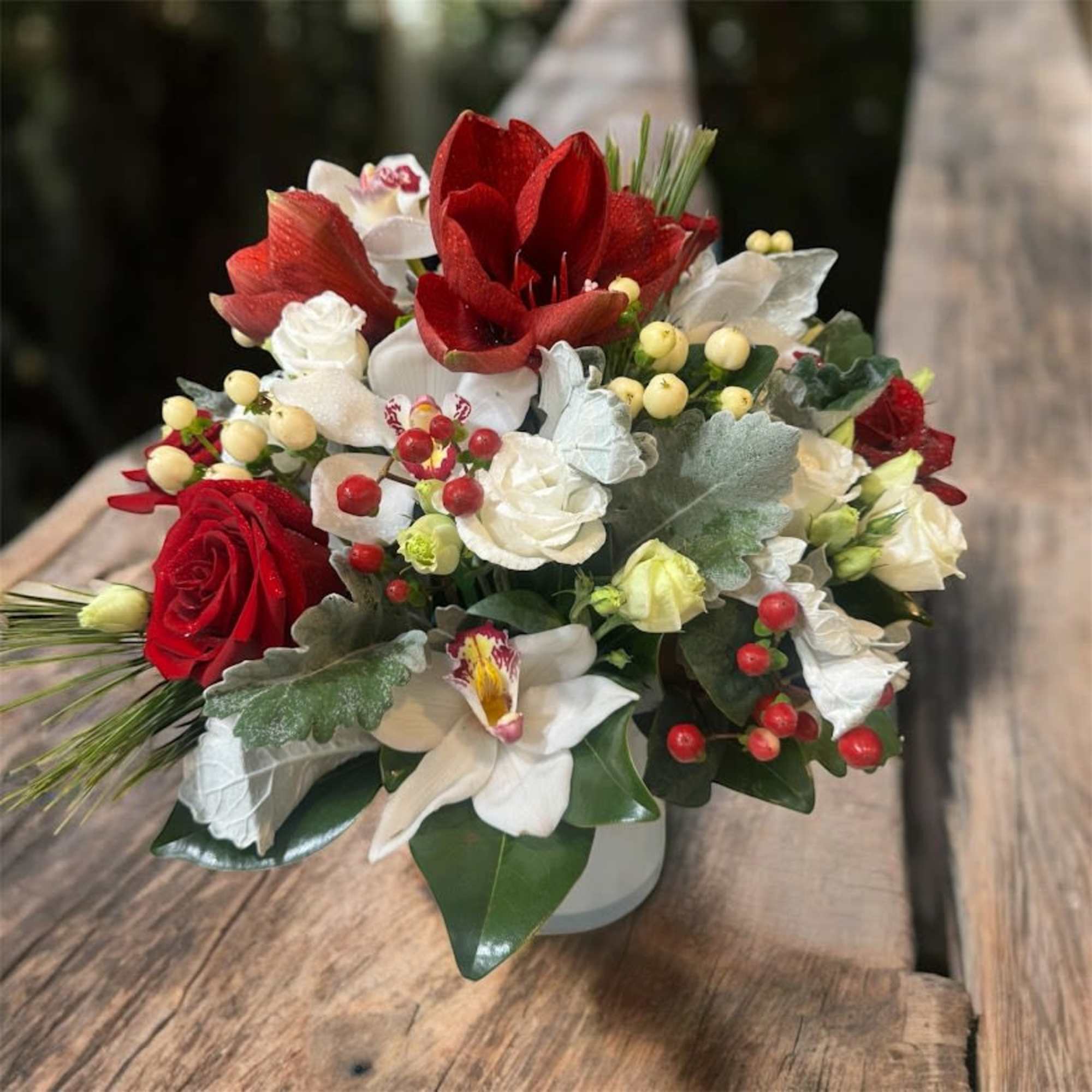 Amaryllis, Roses, Orchids with holiday greeneries in a clear vase
Flowers that are
