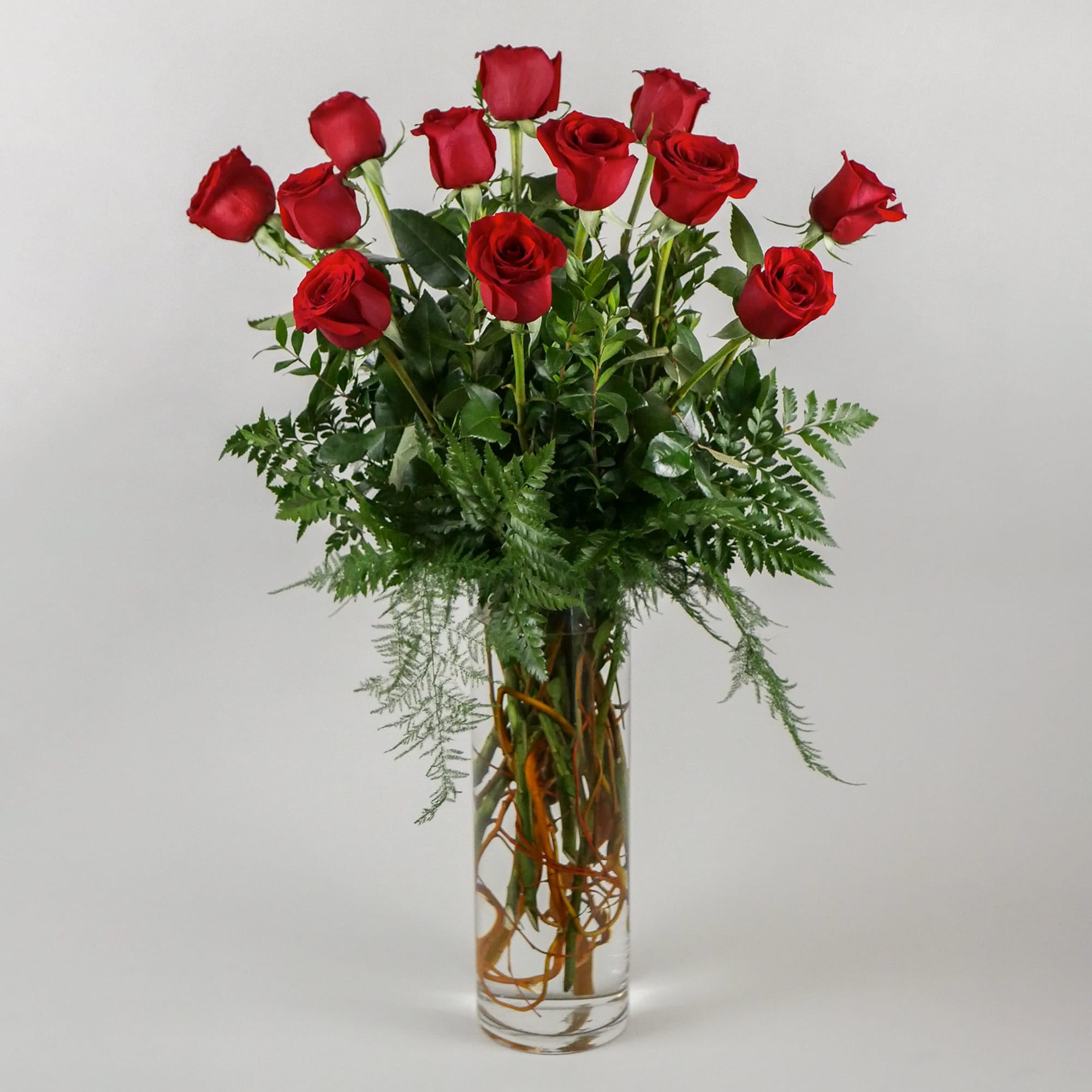 This romantic arrangement features our premium red roses with lush greens in