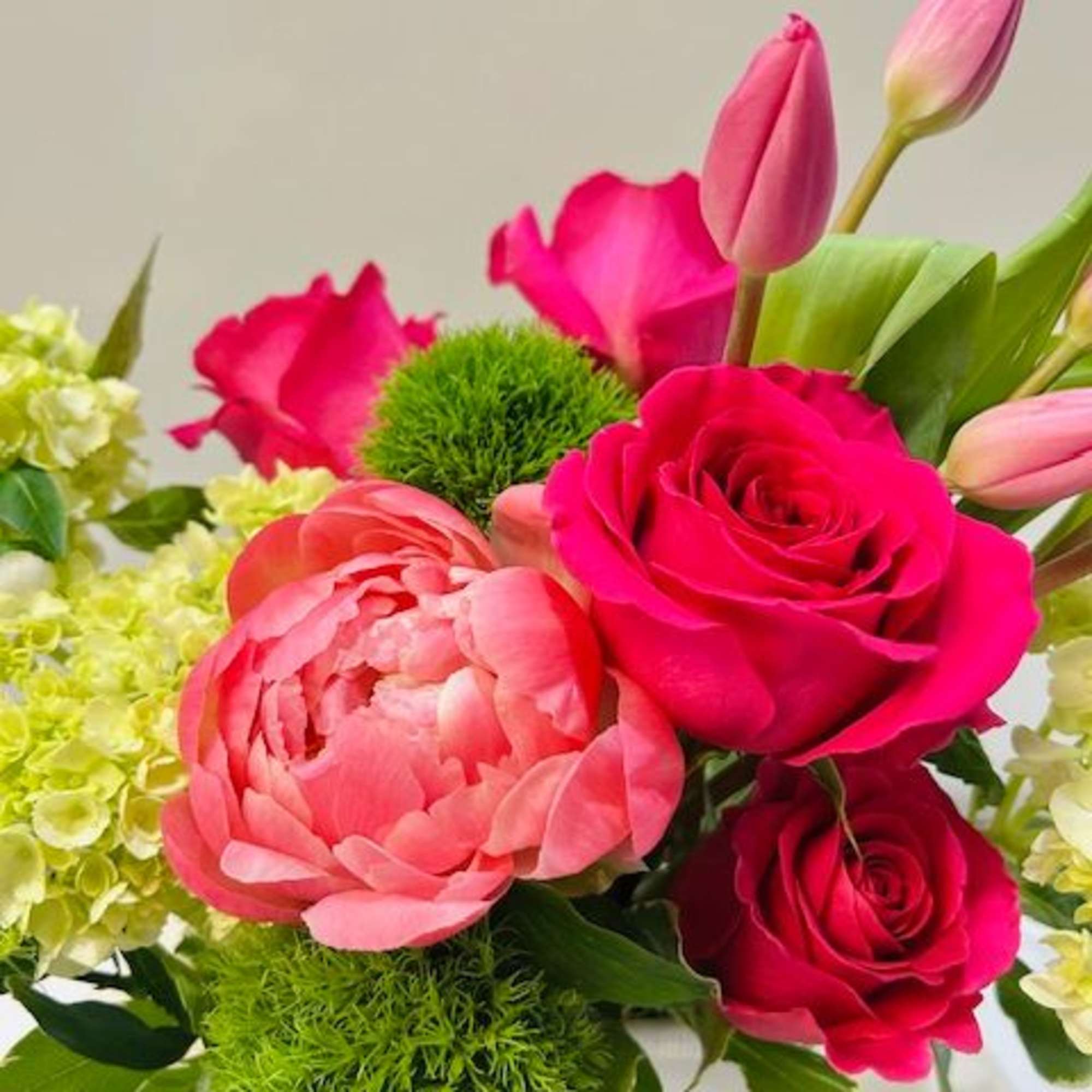 A refined blend of peonies and tulips in complementary tones, designed with