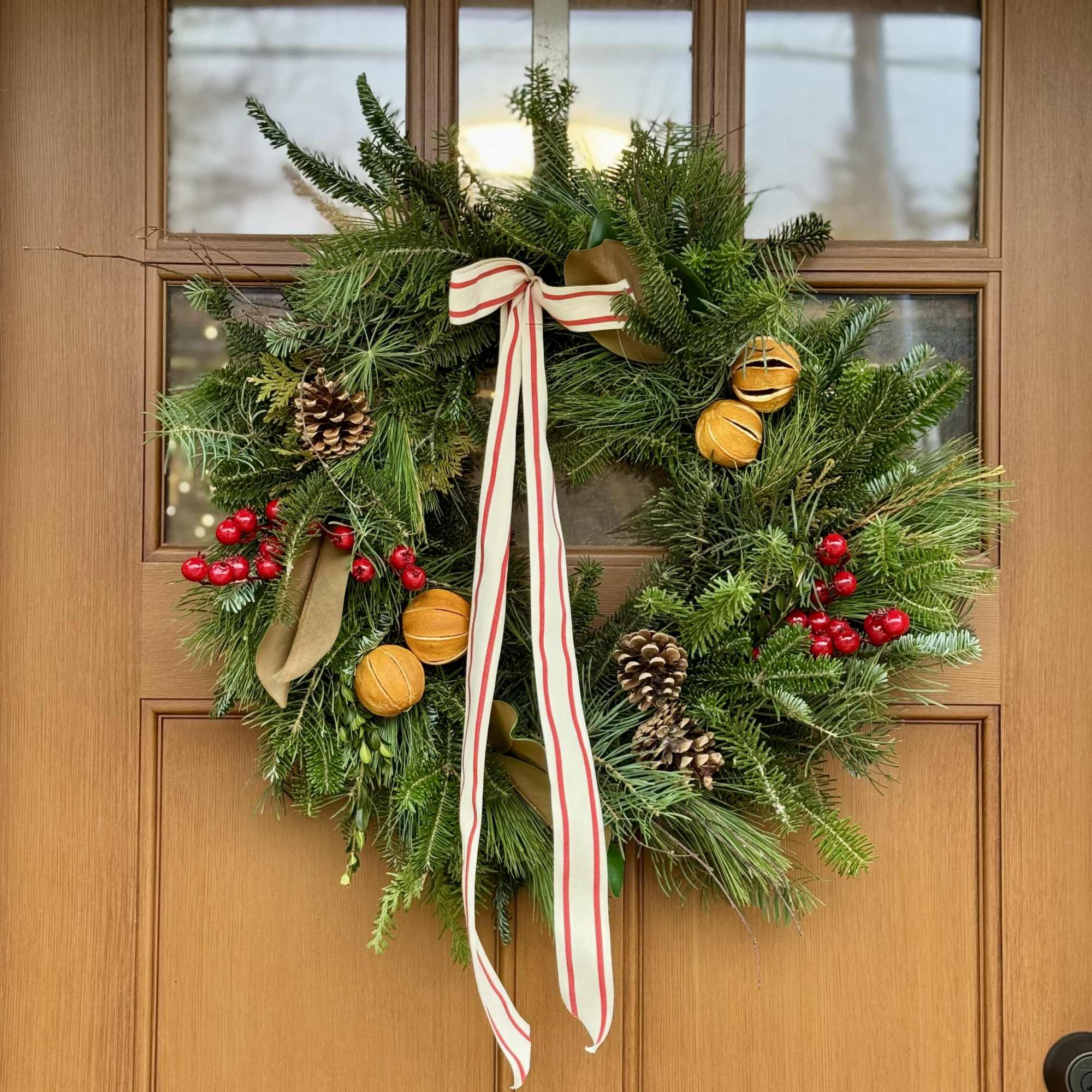 This fresh evergreen wreath is locally handmade and then accented with ribbon