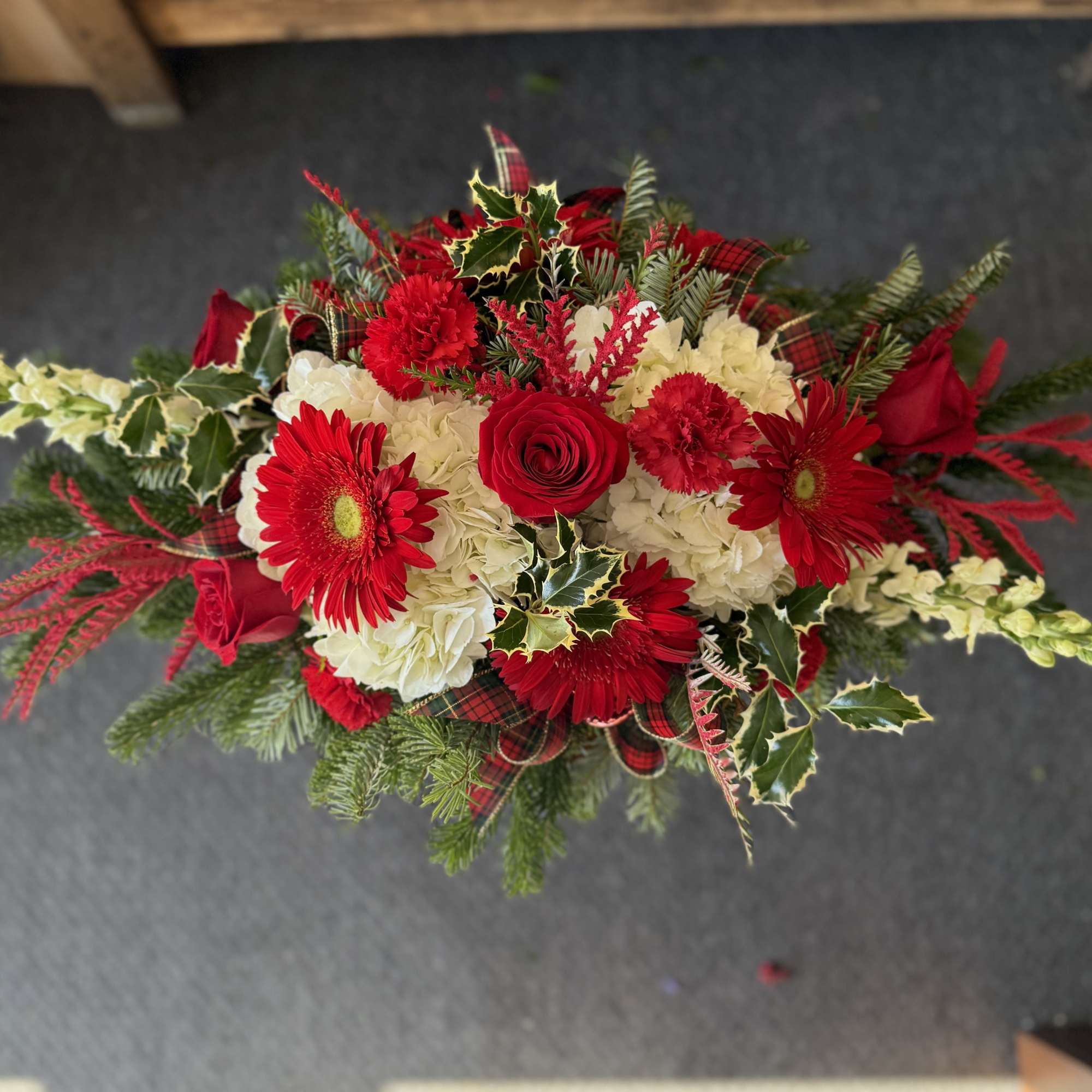 Christmas centerpiece in a specialty gold cube vase filled with hydranges, roses