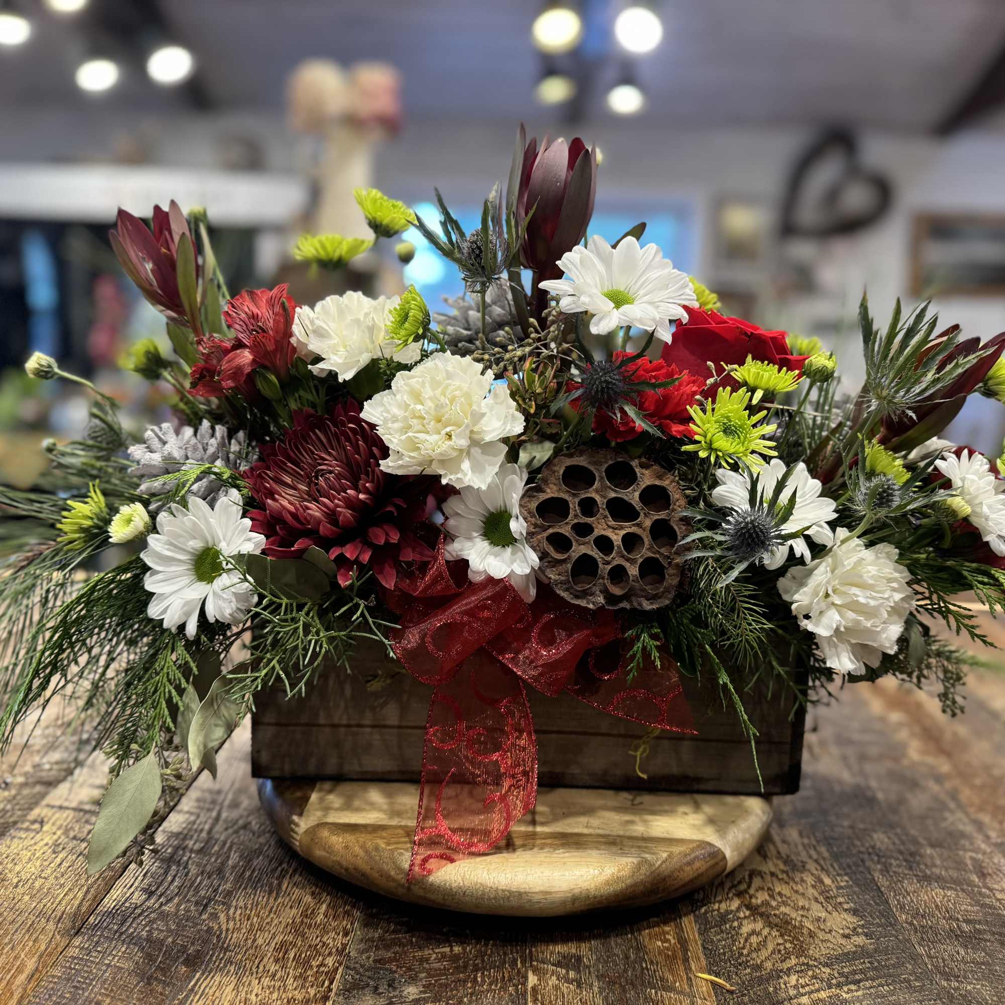 This beautiful festive centerpiece is a showstopper!  Long lasting greens, pinecones