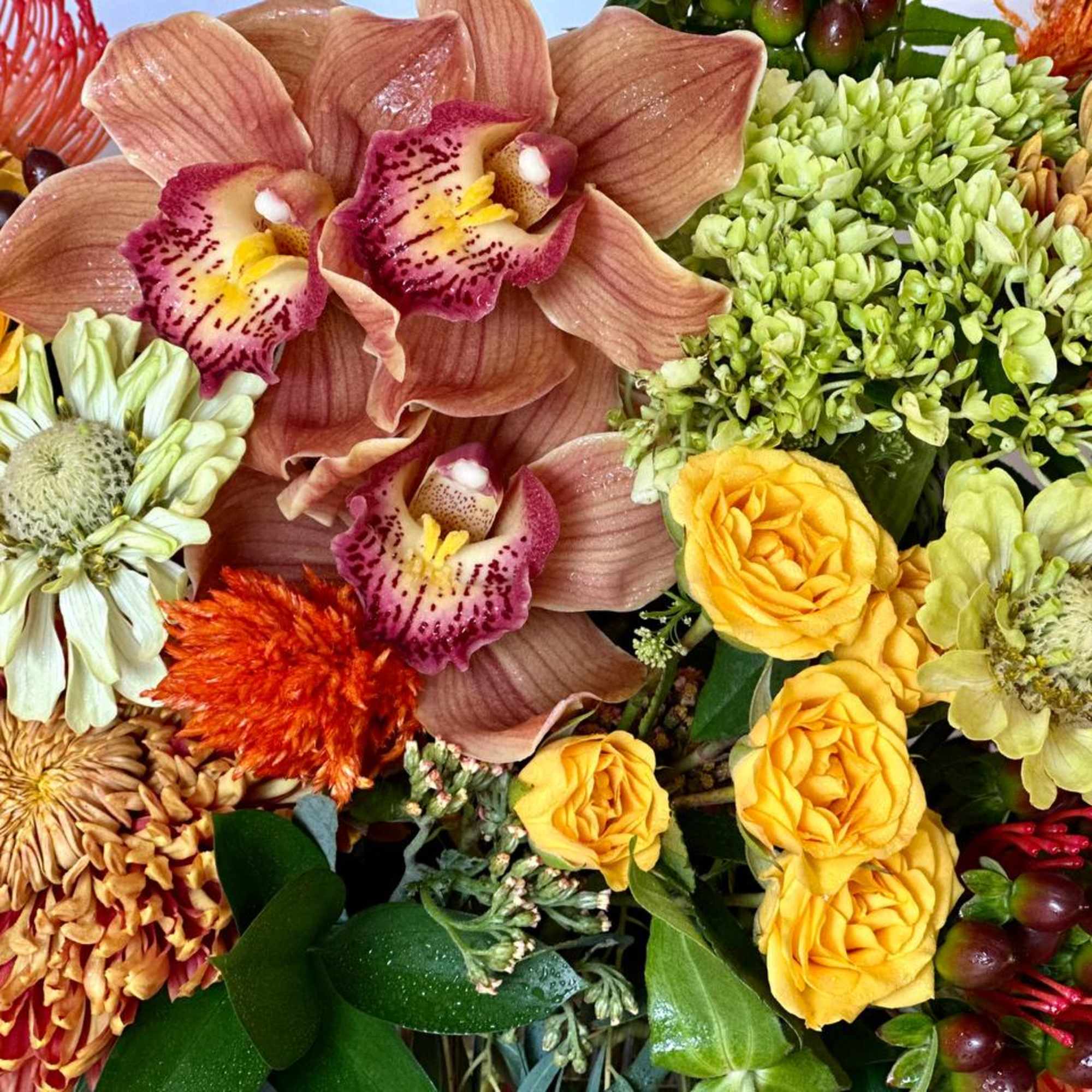 The stunning flower arrangement is made in a unique rectangular vase with