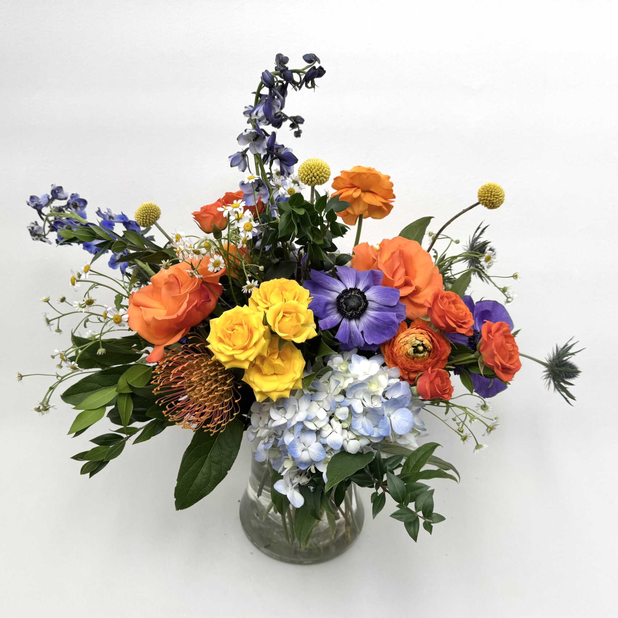 Neptune is a whimsical arrangement with blue, yellow and orange flowers that
