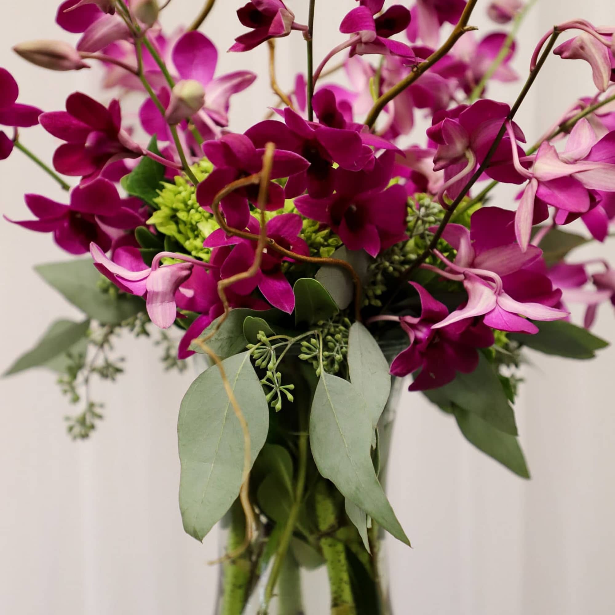 Tall vase of a base of mini green hydrangea with all purple