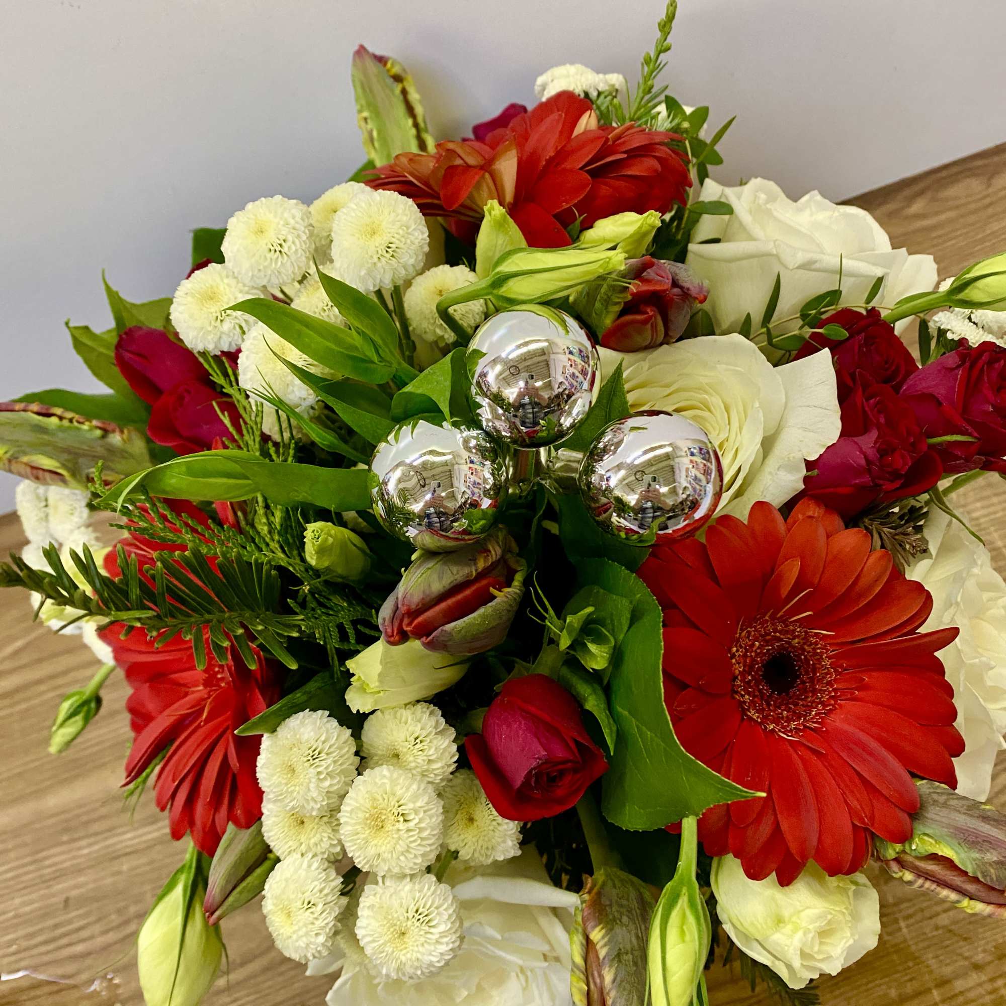 In a glass of waves Christmas greenery with a red Gerber, red