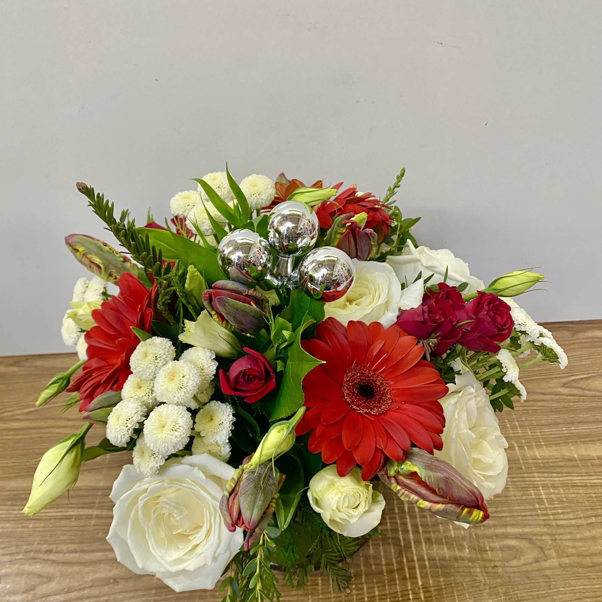 In a glass of waves Christmas greenery with a red Gerber, red