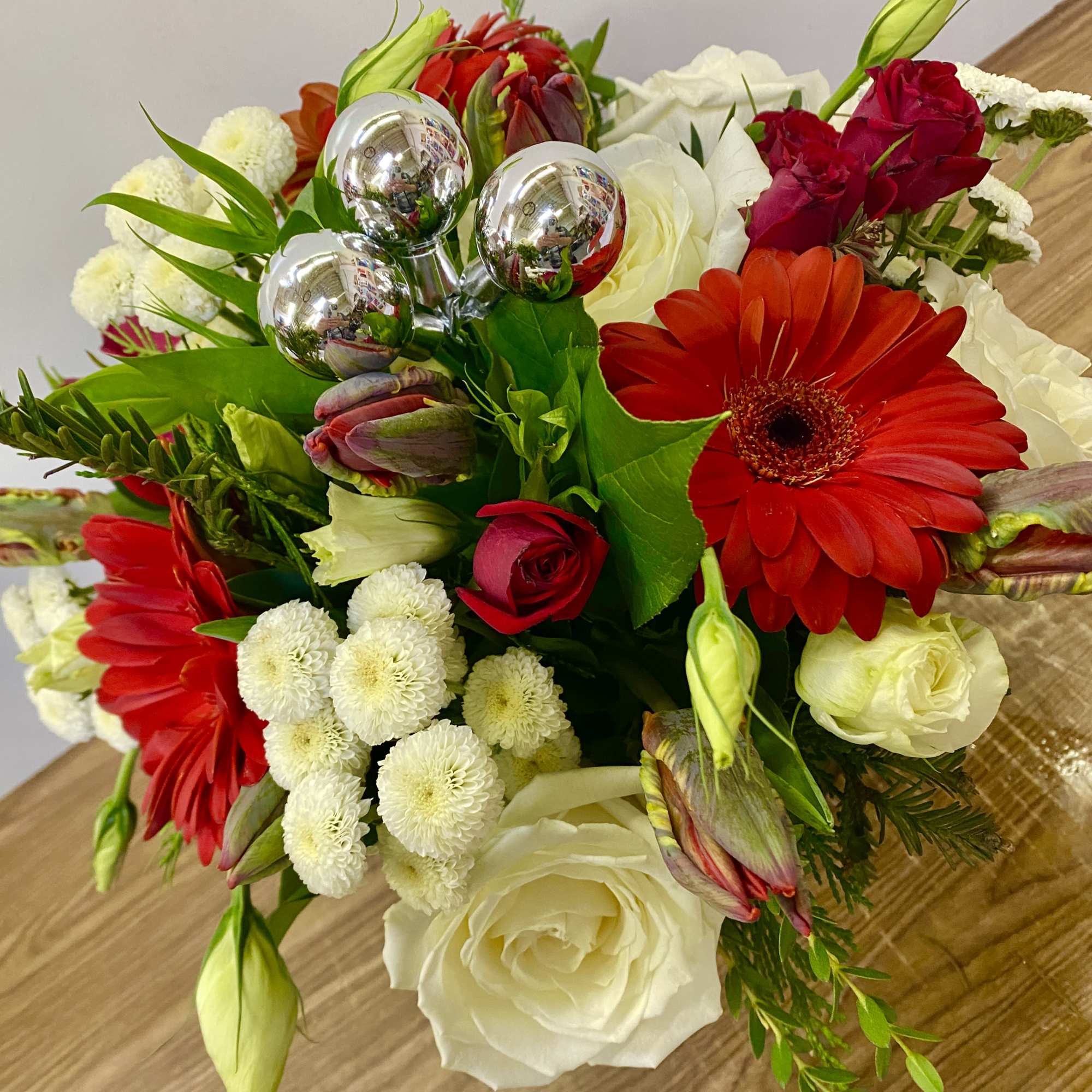 In a glass of waves Christmas greenery with a red Gerber, red