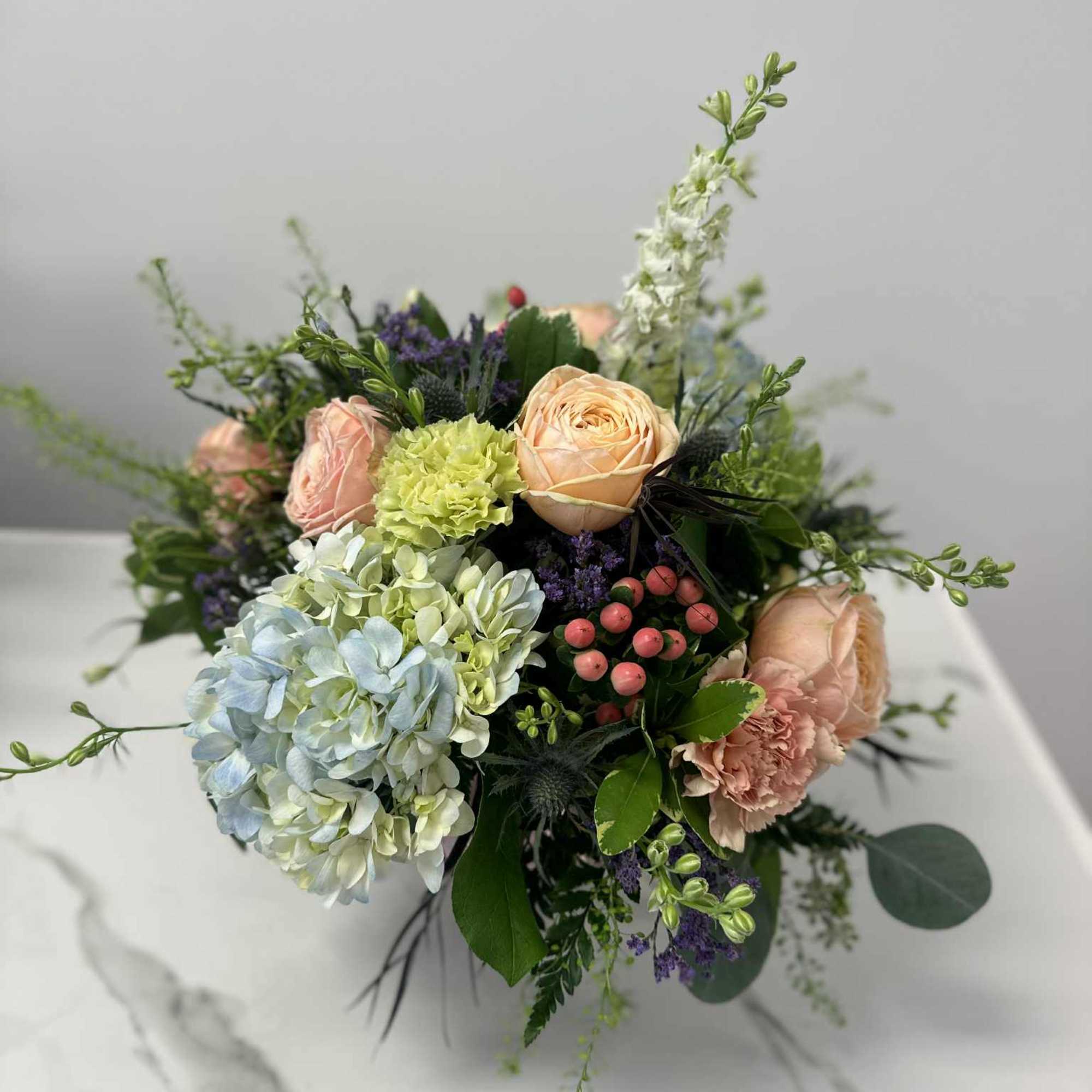 Soft and sweet, this pastel pink rose-light blue bouquet gets the glam