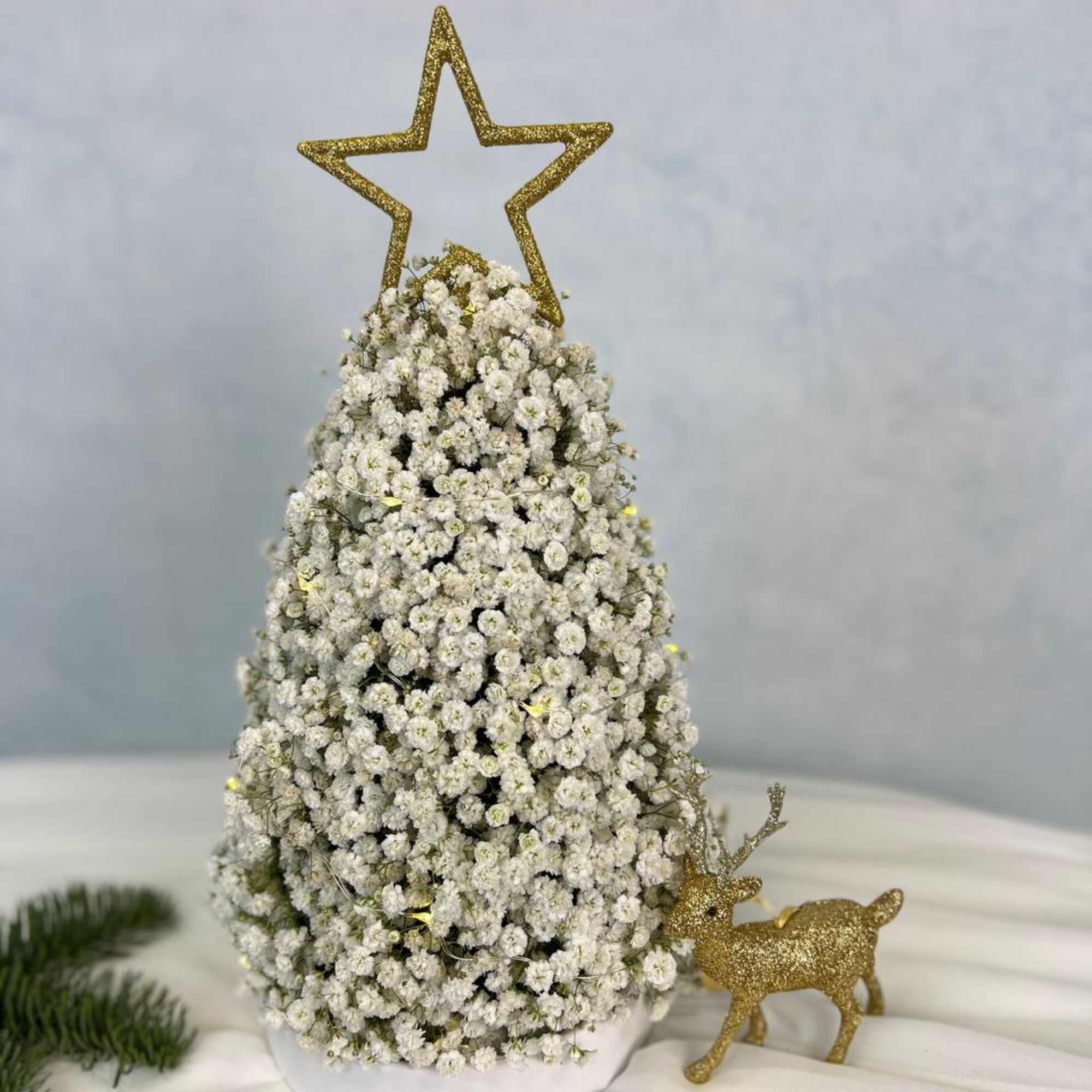 A luxurious winter tree crafted from clouds of baby&rsquo;s breath and crowned