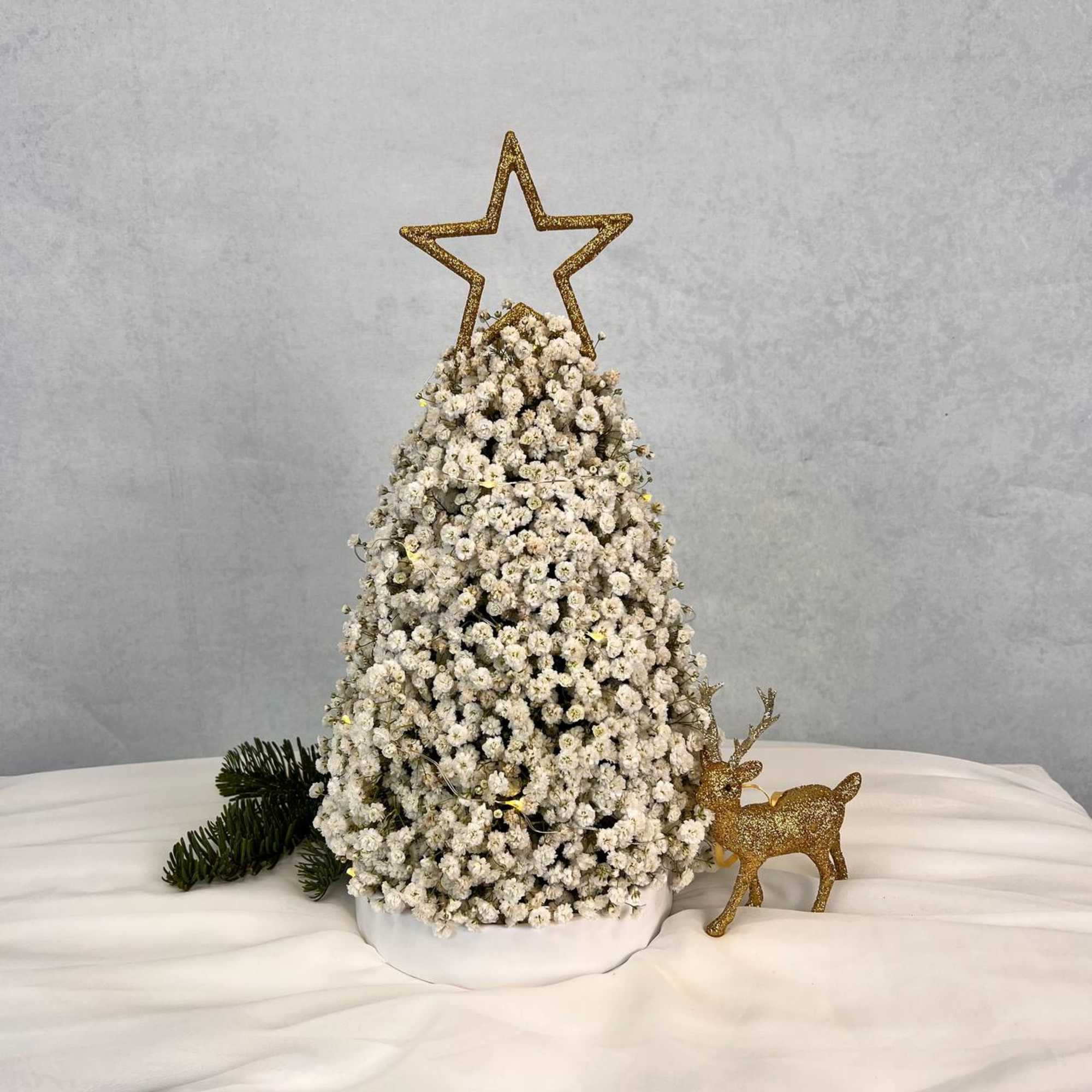A luxurious winter tree crafted from clouds of baby&rsquo;s breath and crowned