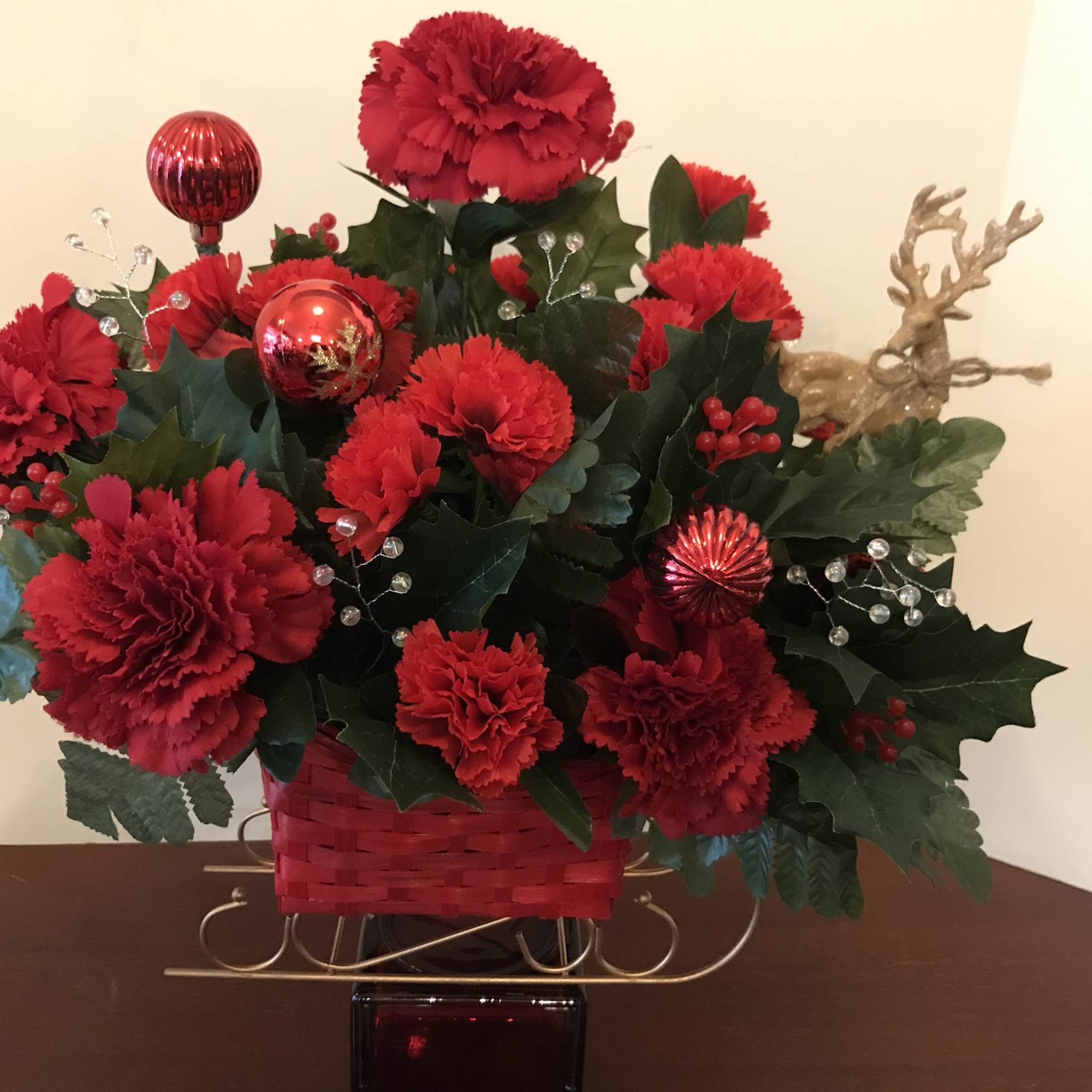 This arrangement features a red sleigh with golden highlights.  It is