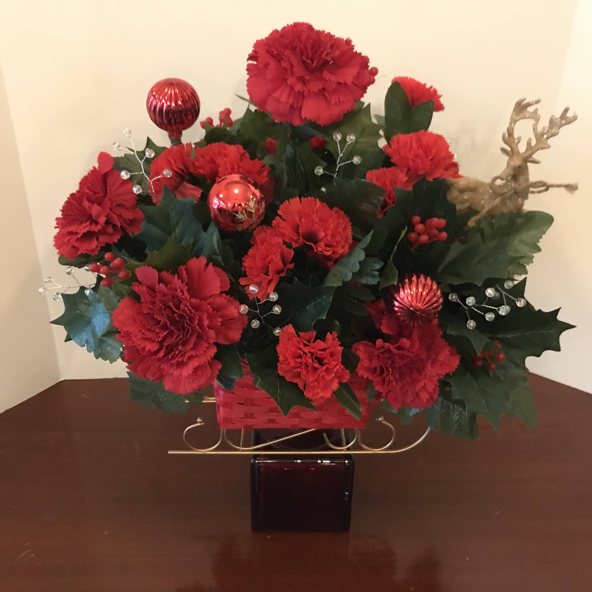 This arrangement features a red sleigh with golden highlights.  It is