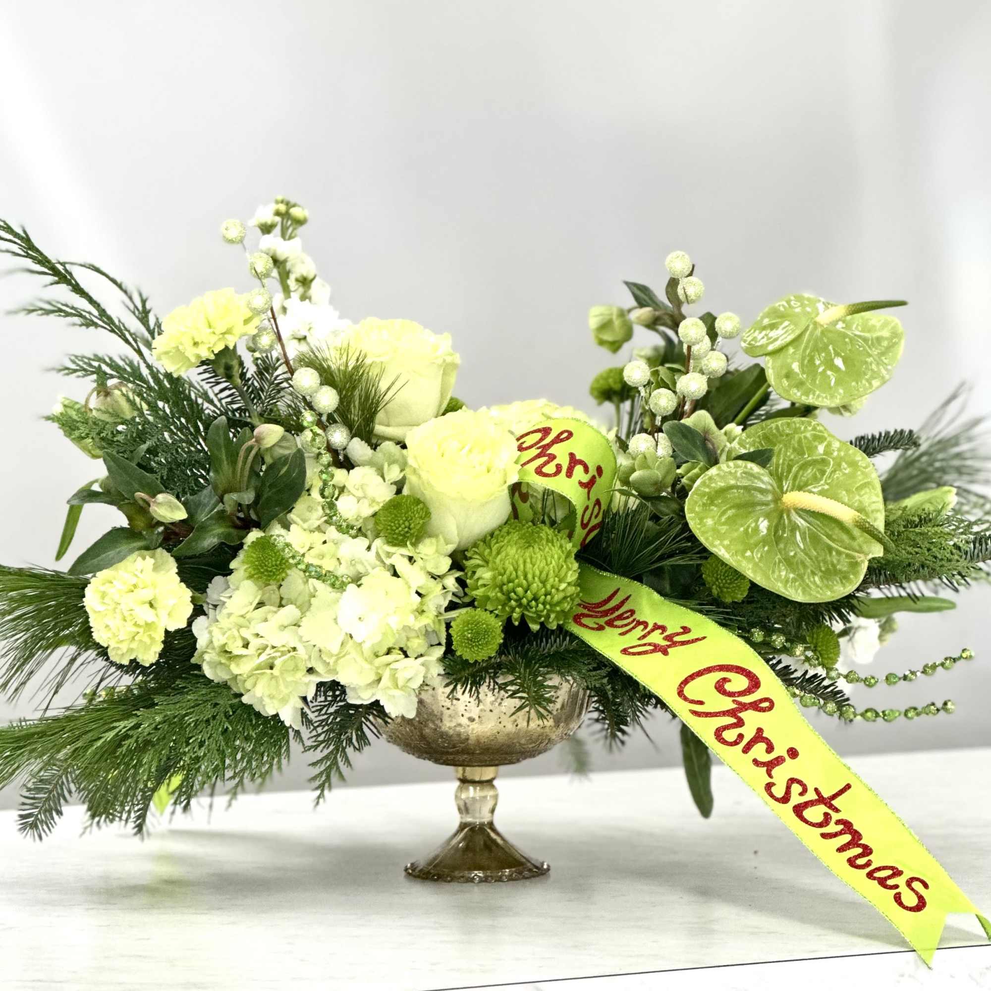 Impress your guests with Mrs. Grinchmas, an elegant floral centerpiece featuring green