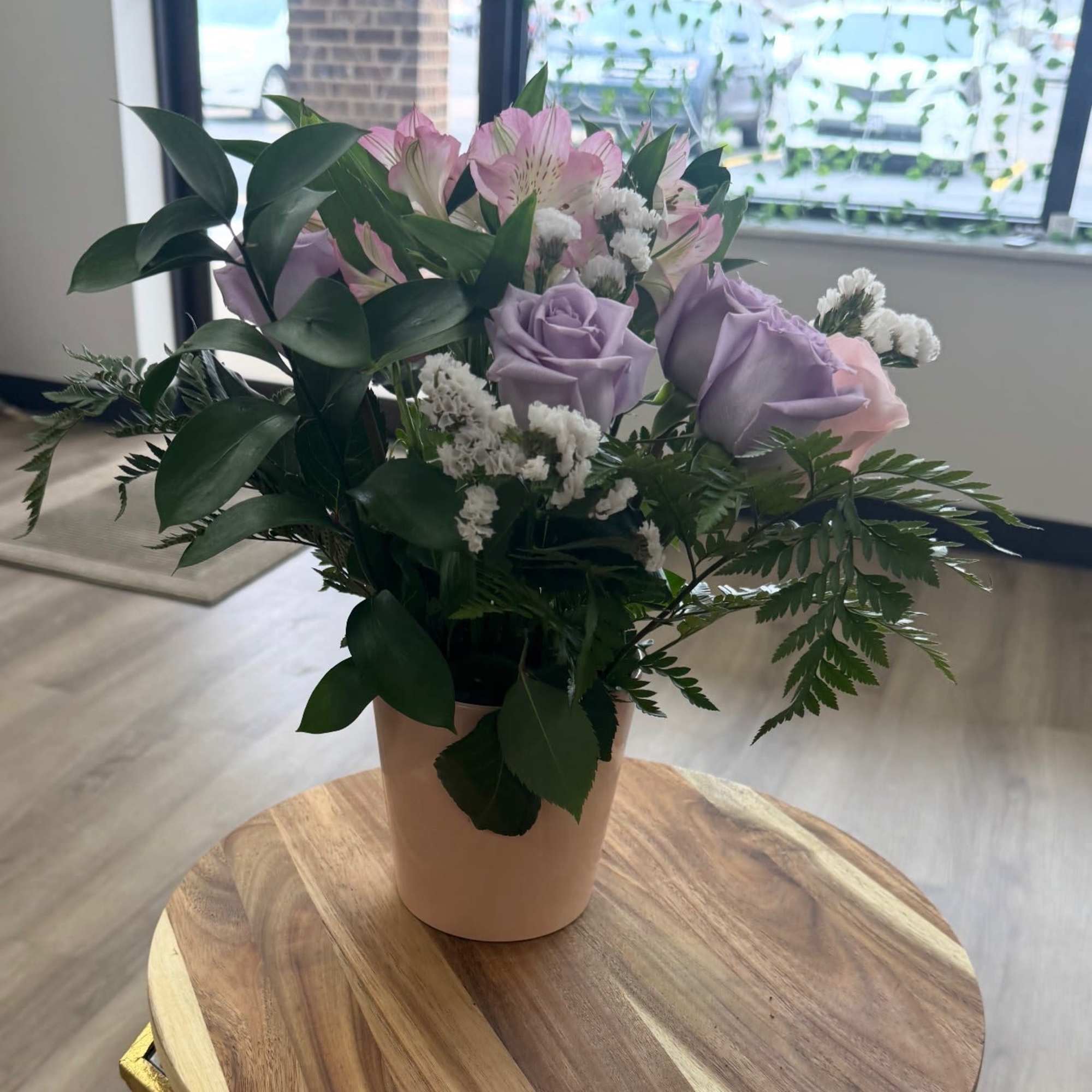 A soft and romantic arrangement featuring delicate lavender roses, blush pink roses