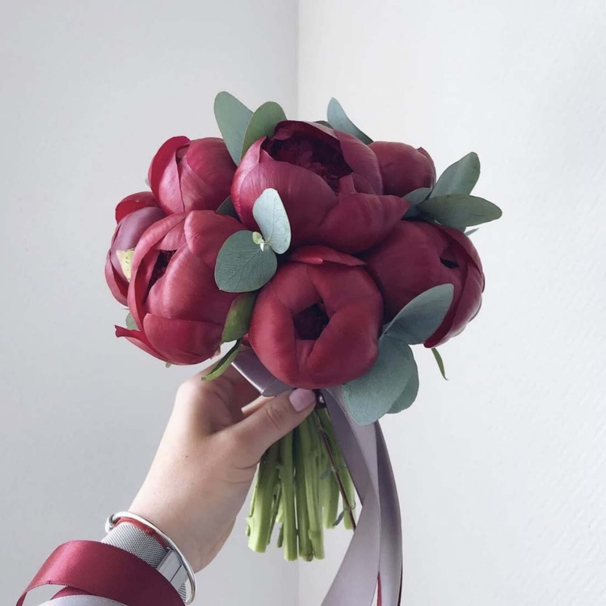 Classic round bridal bouquet of burgundy peonies.

The color scheme of the bouquet