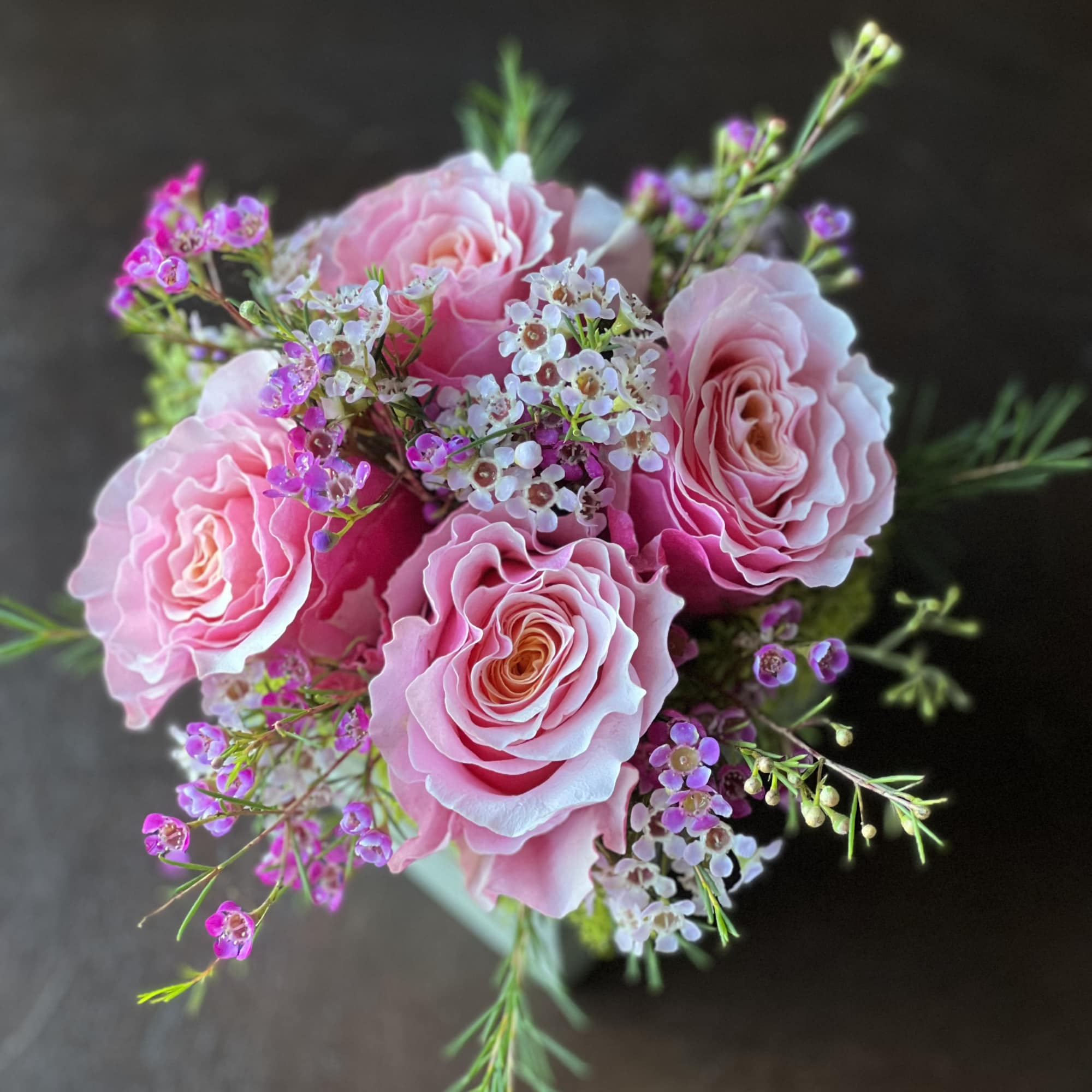 Blushing pink Roses accented by dainty pink and white Waxflower blooms and