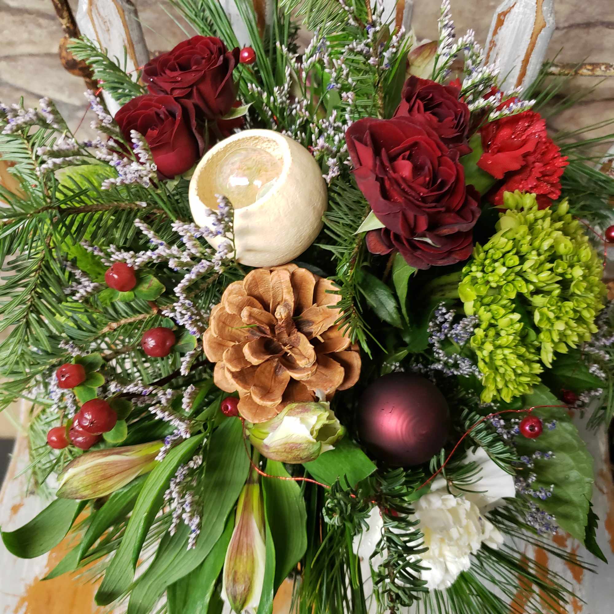 Seasonal evergreens, with a touch of blooms would vary.
The gray/silver tone enhances