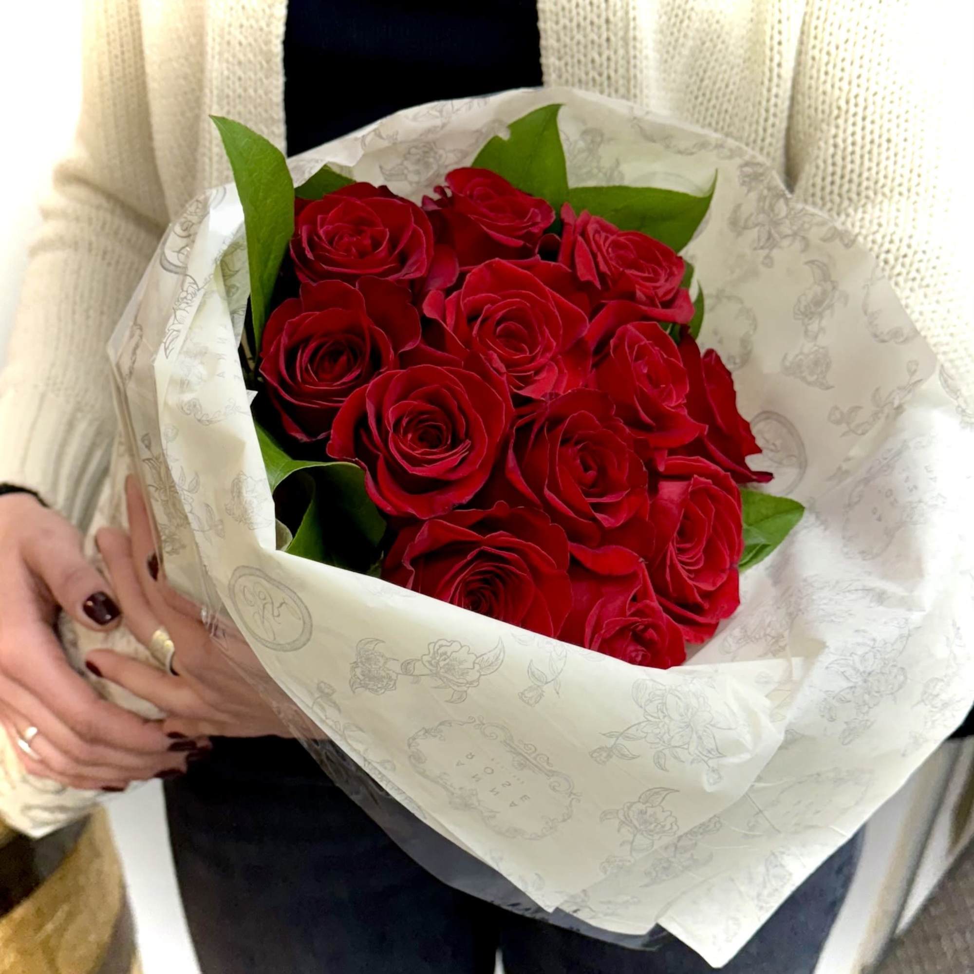 A Dozen Red Roses in a Modern Design with Simple Greens. Wrapped