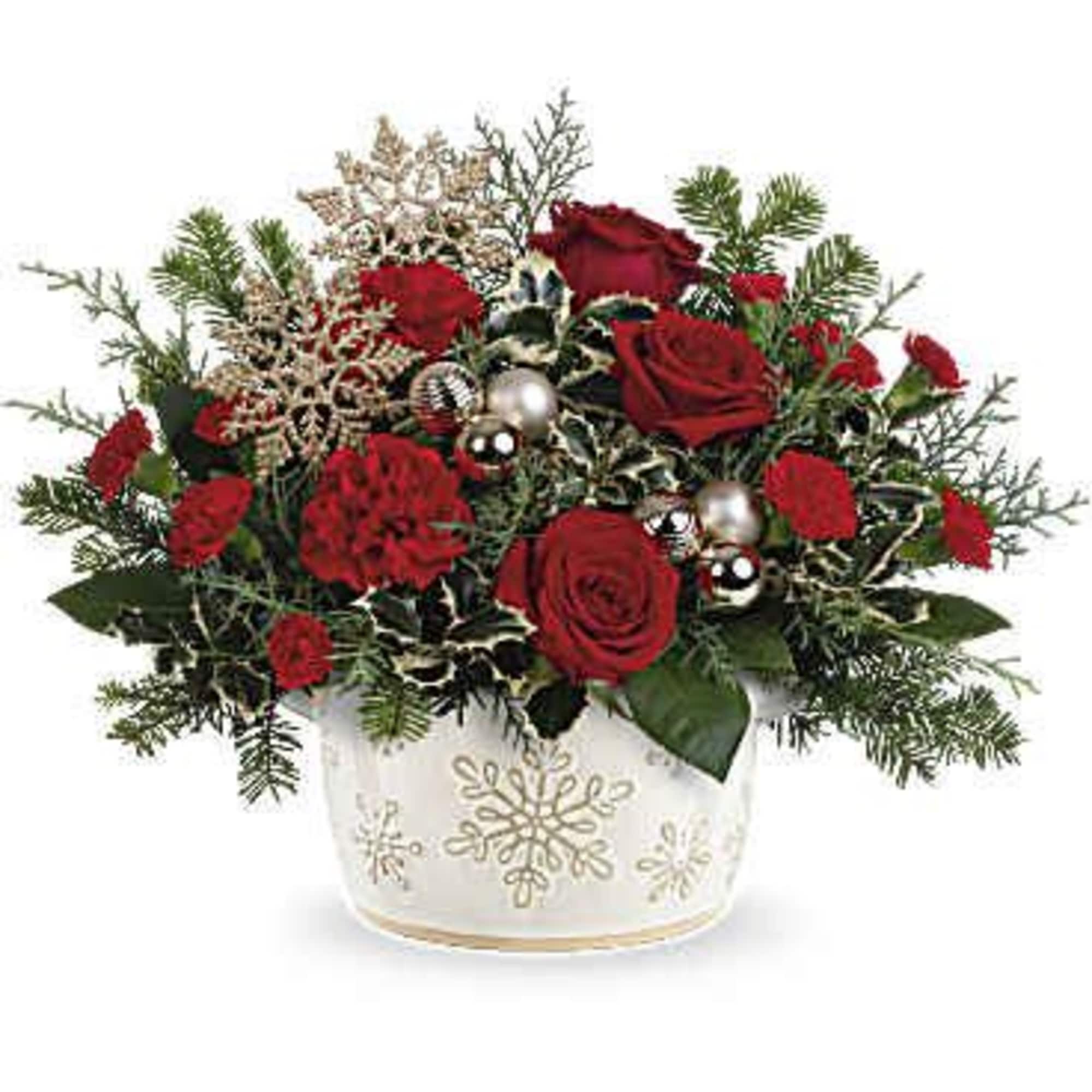 Teleflora's Snowflake Symphony Centerpiece features vibrant red roses, classic red carnations, and