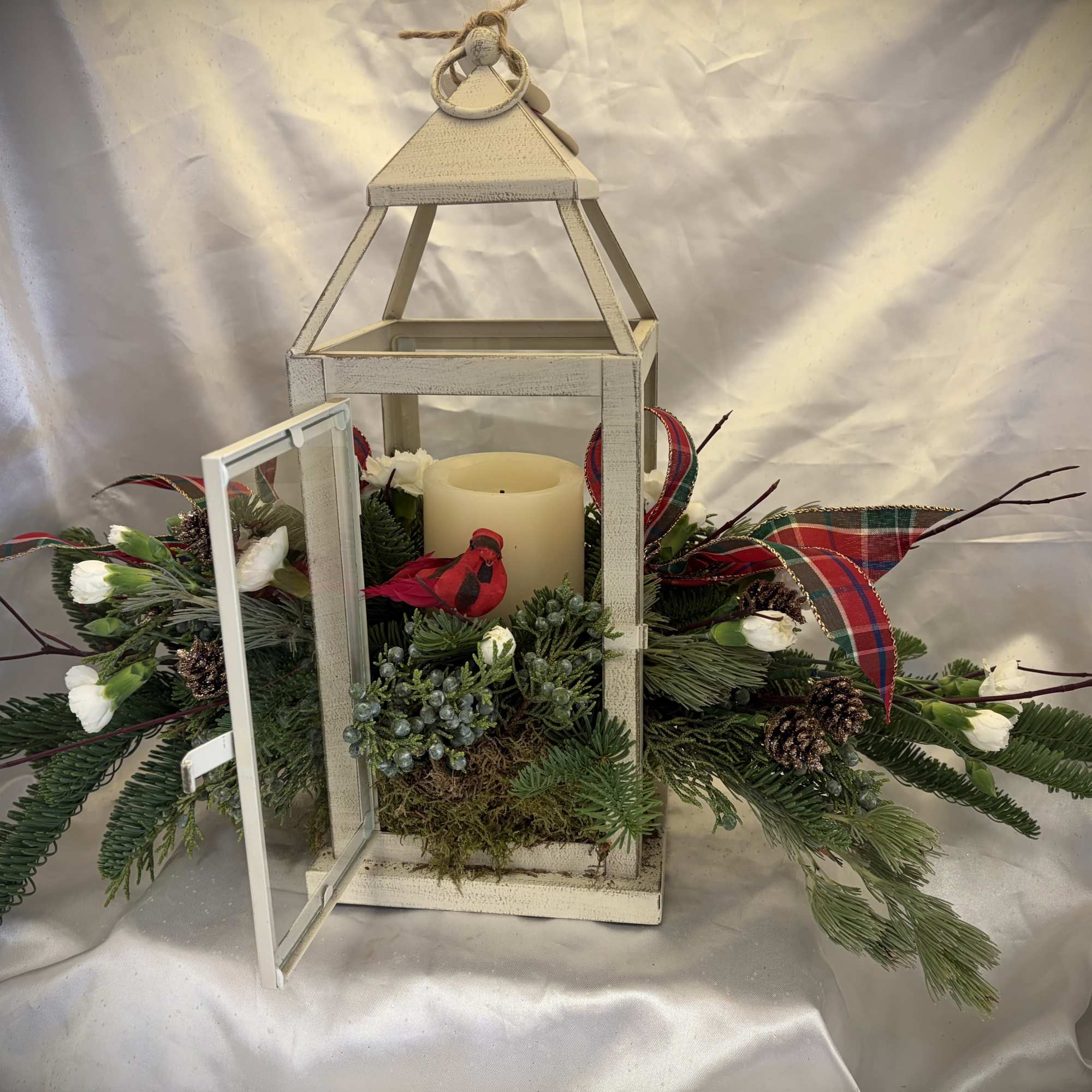 Beautiful, rustic lantern with candle and festive greens adorned with a charming