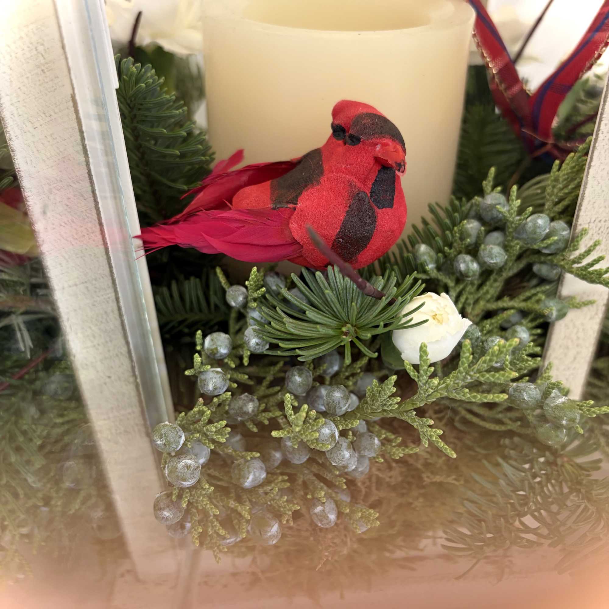 Beautiful, rustic lantern with candle and festive greens adorned with a charming