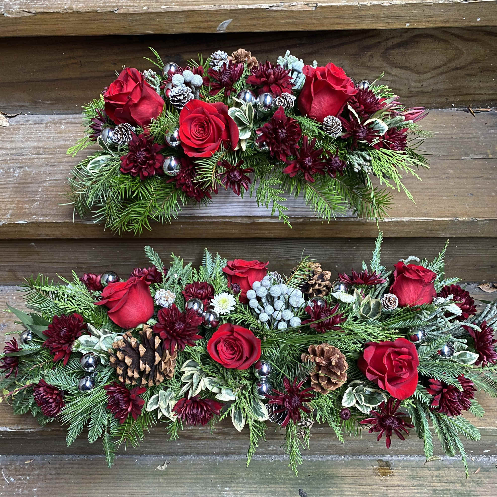 Long and narrow centerpiece of evergreen, Burgundy Mums, Red Roses,  pinecones