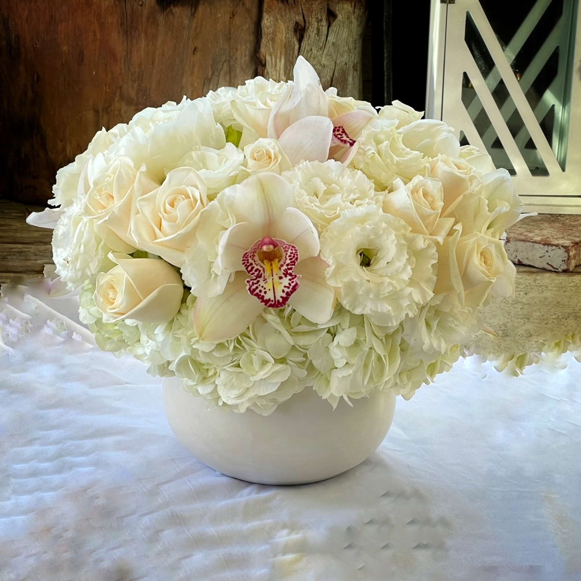 Premium Roses, Hydrangea, Lisianthus, Cymbidium Orchid,... in white ceramic vase.