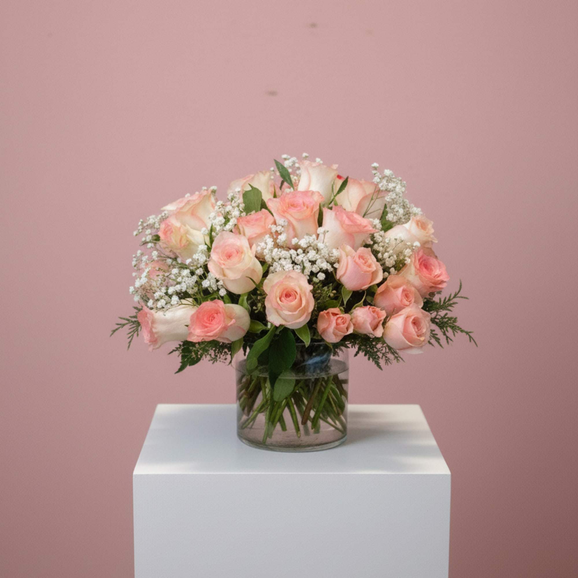 This arrangement of all pink roses and spray roses accented with babies