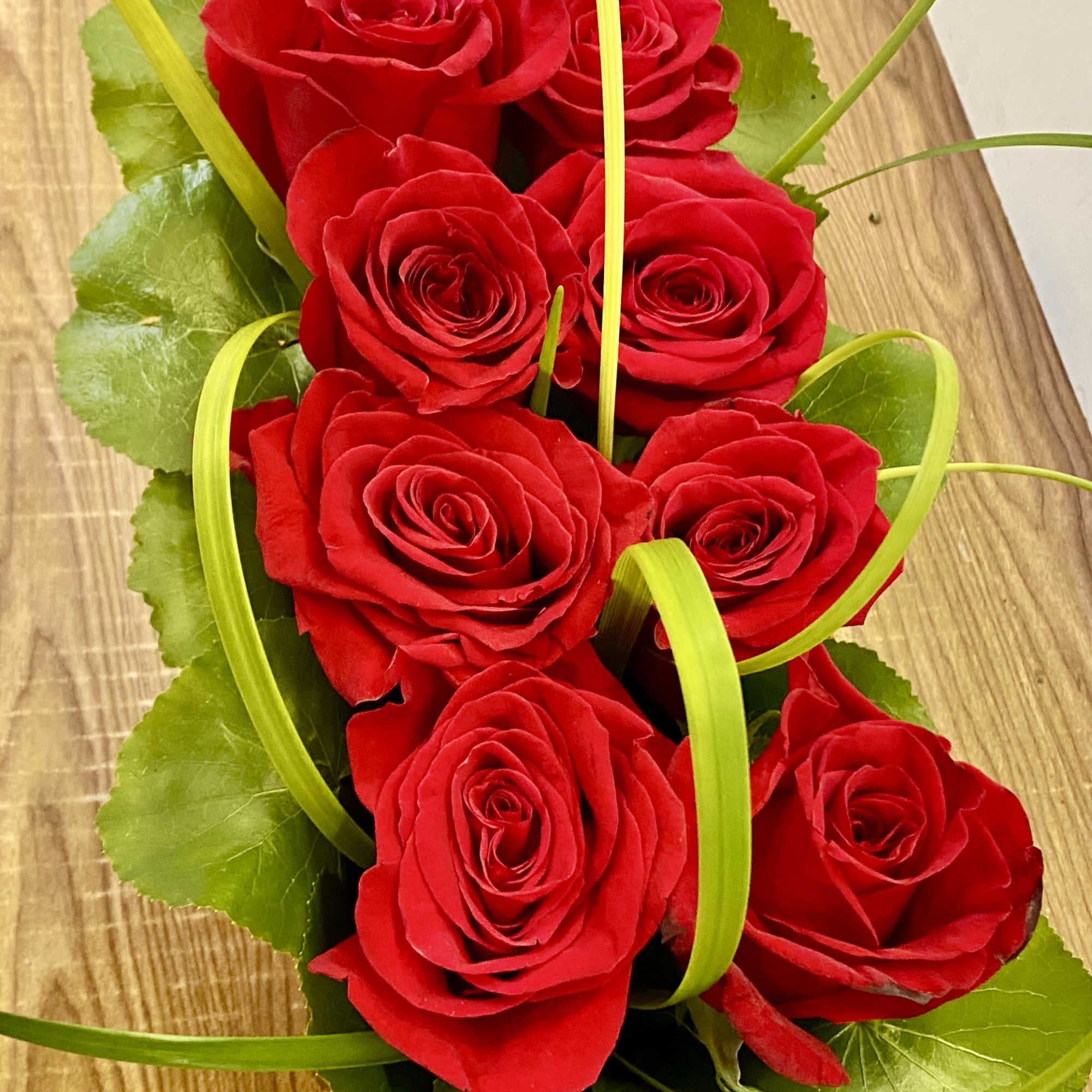 8 red roses in a fancy wood basket 
