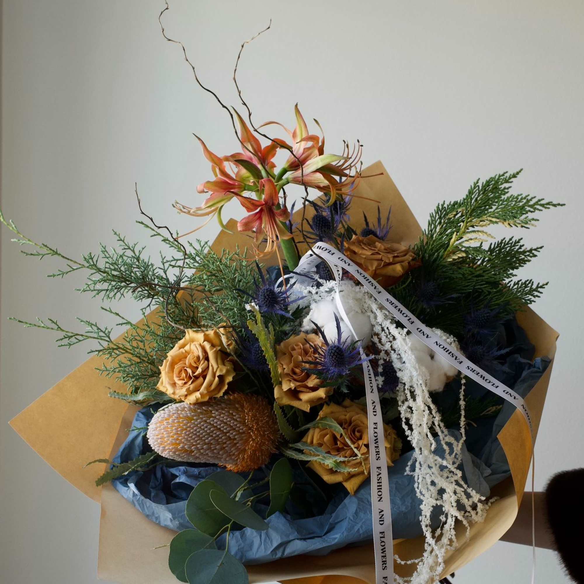 A warm and thoughtfully designed winter-inspired bouquet featuring soft amber tones, seasonal