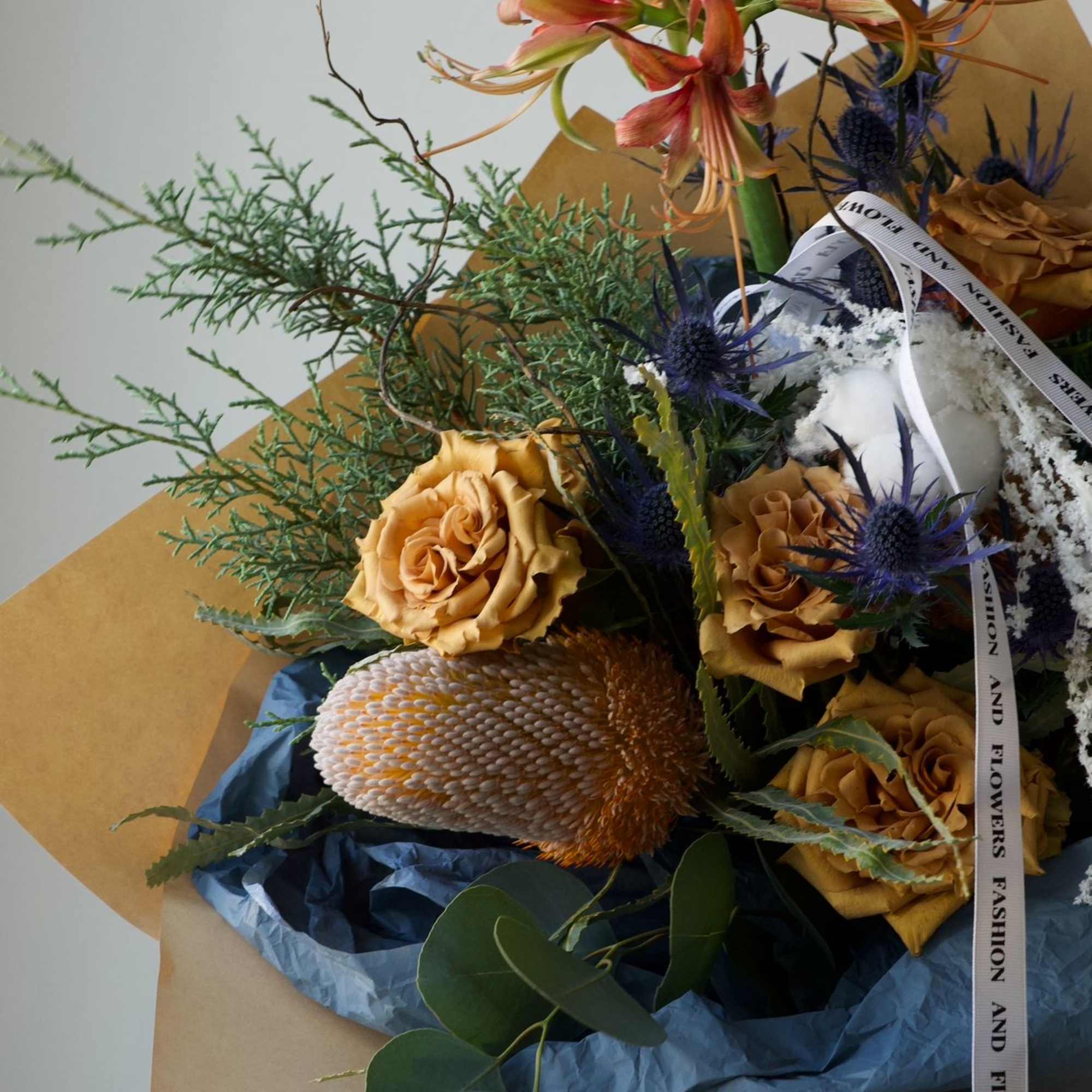 A warm and thoughtfully designed winter-inspired bouquet featuring soft amber tones, seasonal