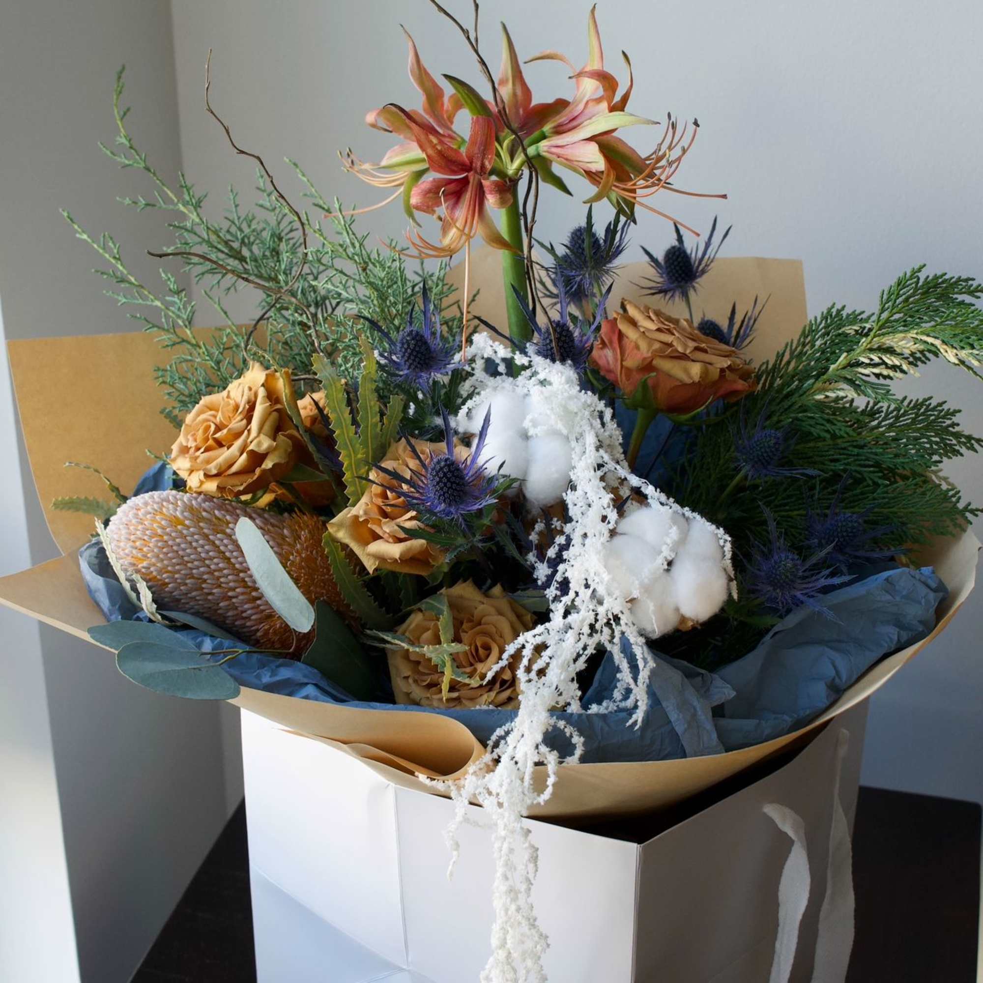 A warm and thoughtfully designed winter-inspired bouquet featuring soft amber tones, seasonal