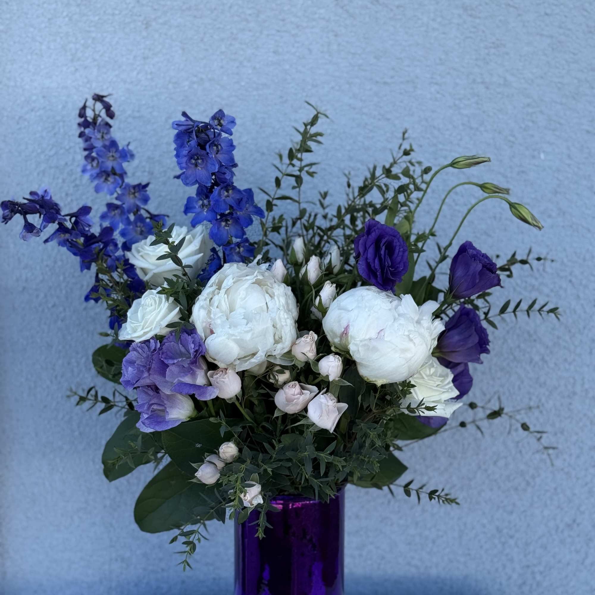 Purple arrangement

Roses
Lisianthus
Peonies
Eucalyptus


If a particular flower, is unavailable, an item of similar quality