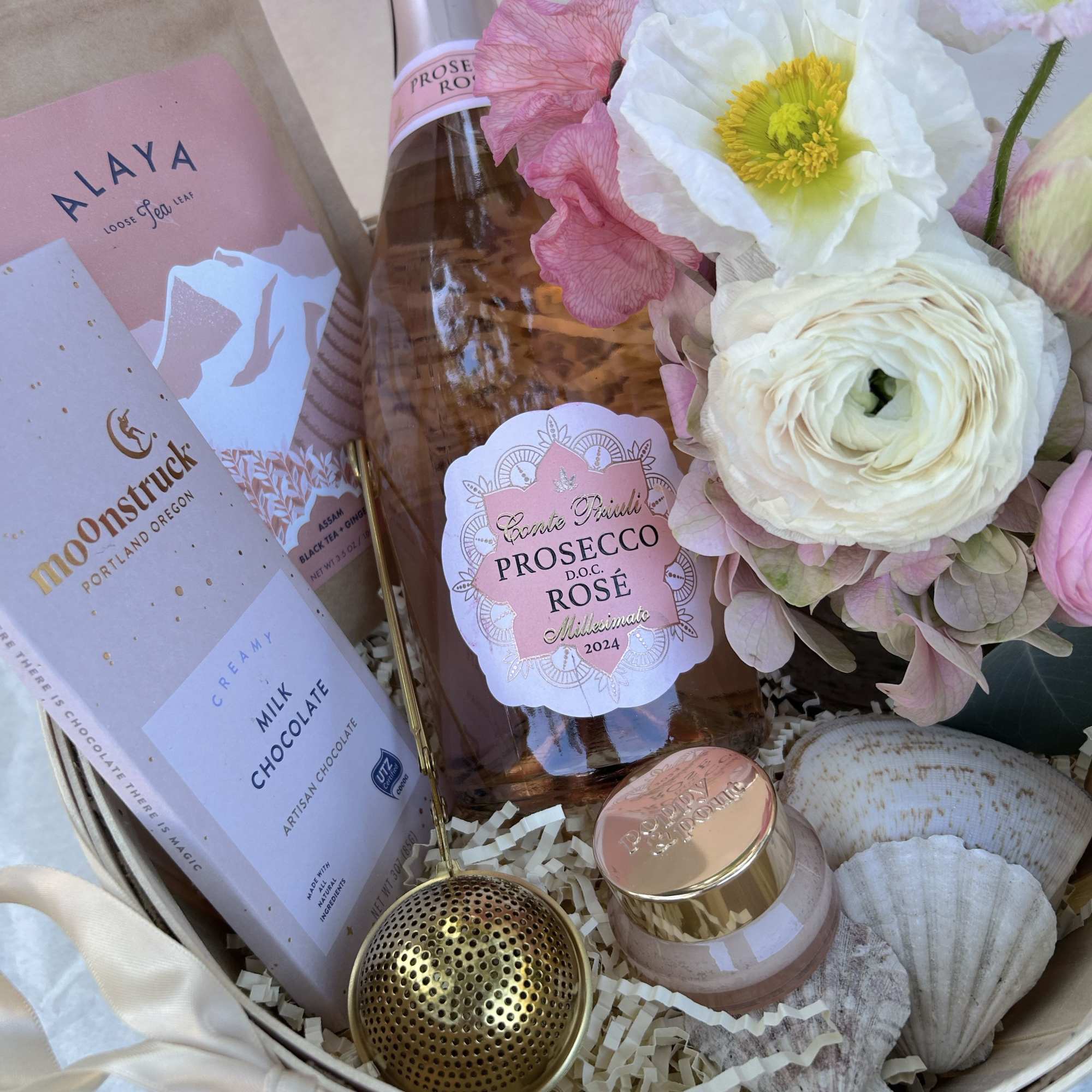A celebration box with bubbly, chocolate, fresh flowers and a Liberty x
