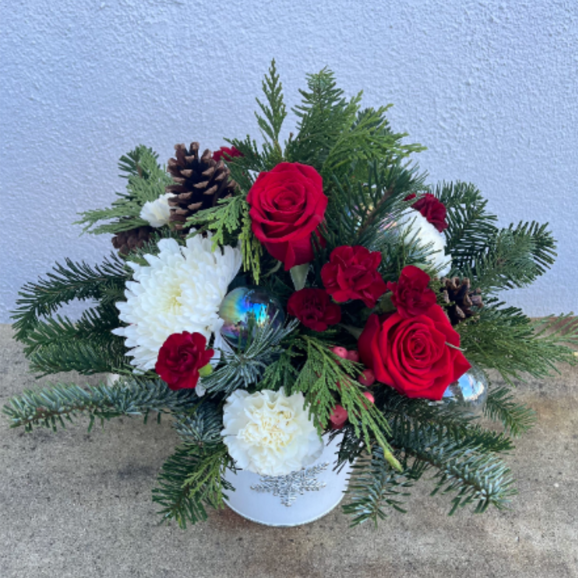 This arrangement is in a holiday keepsake metal pot, filled with Red